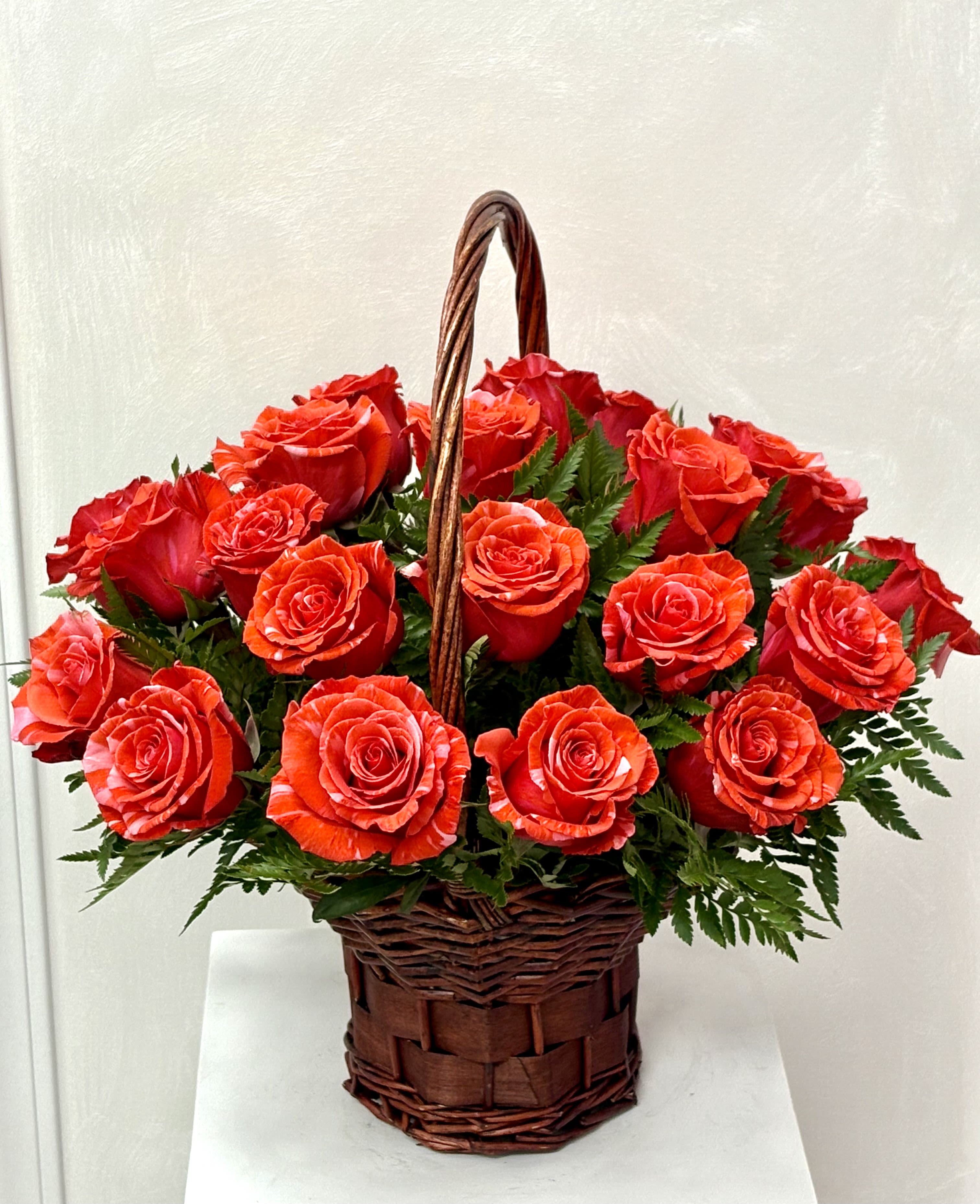 Basket of red roses with greenery