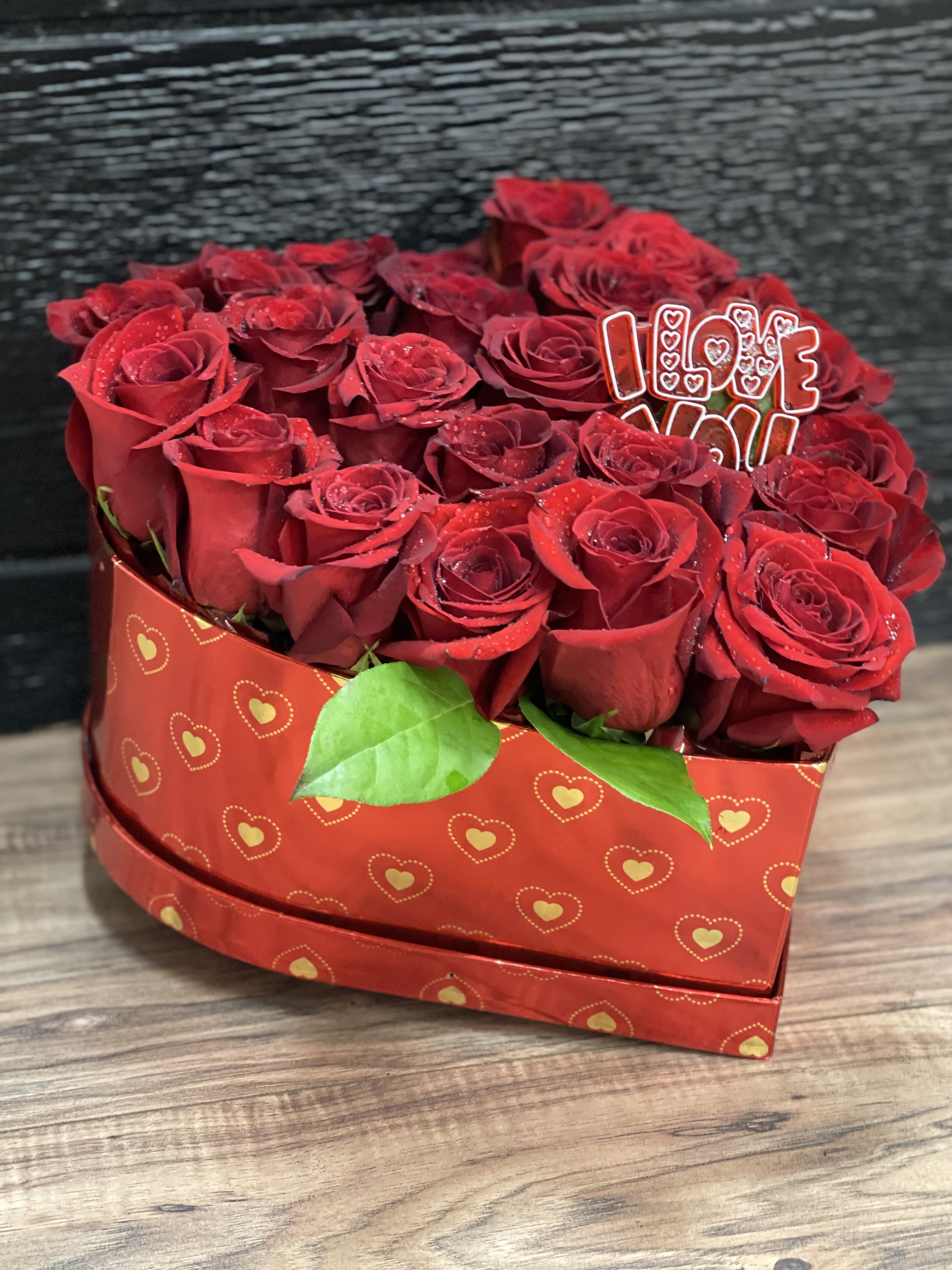 Heart-shaped box of red roses with an "I LOVE YOU" topper
