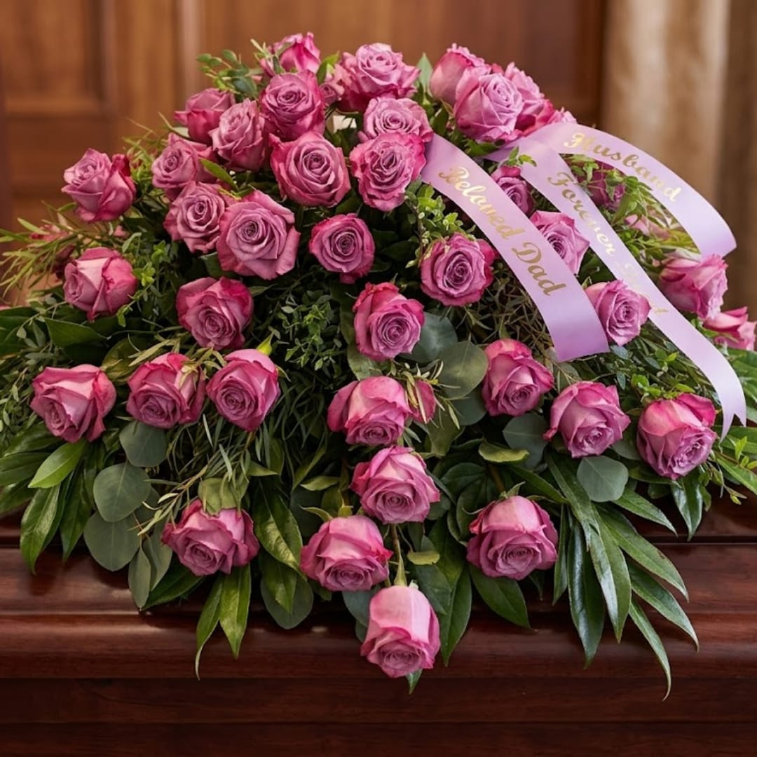 Pink rose arrangement with ribbon on a wooden surface