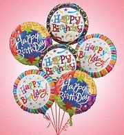 Cluster of colorful Happy Birthday balloons on a pink background