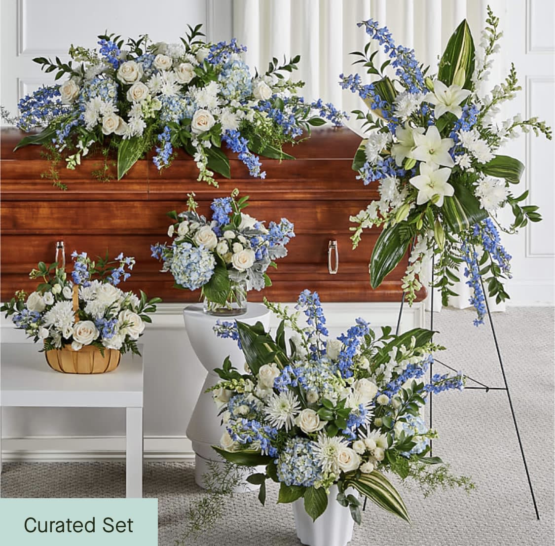 Blue and white floral funeral set with casket spray, standing spray, and vase arrangements