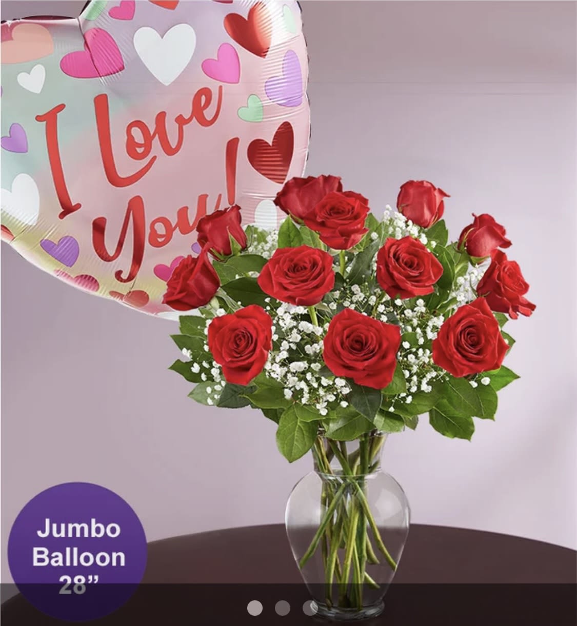 Red roses in a glass vase with a heart-shaped "I Love You" balloon
