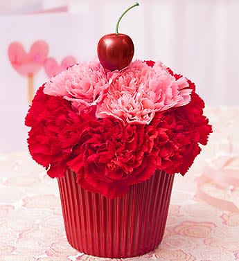 Cupcake For Your Cupcake - Product ID: 95167  EXCLUSIVE Send a sweet surprise their way. Without all the calories. This truly original, hand-crafted pink and red carnation confection brings lasting smiles and playful beauty to their day. We've even added a cherry on top for a stylish finishing touch. Yum! Cupcake-shaped arrangement of the freshest pink and red carnations Artistically designed by our expert florists in a plastic liner resembling a cupcake cup Topped with a red cherry pick for a little more sweet style Arrives in our exclusive cupcake box where available Arrangement measures approximately 6.5"H x 5.5"L Our florists select the freshest flowers available so colors and varieties may vary