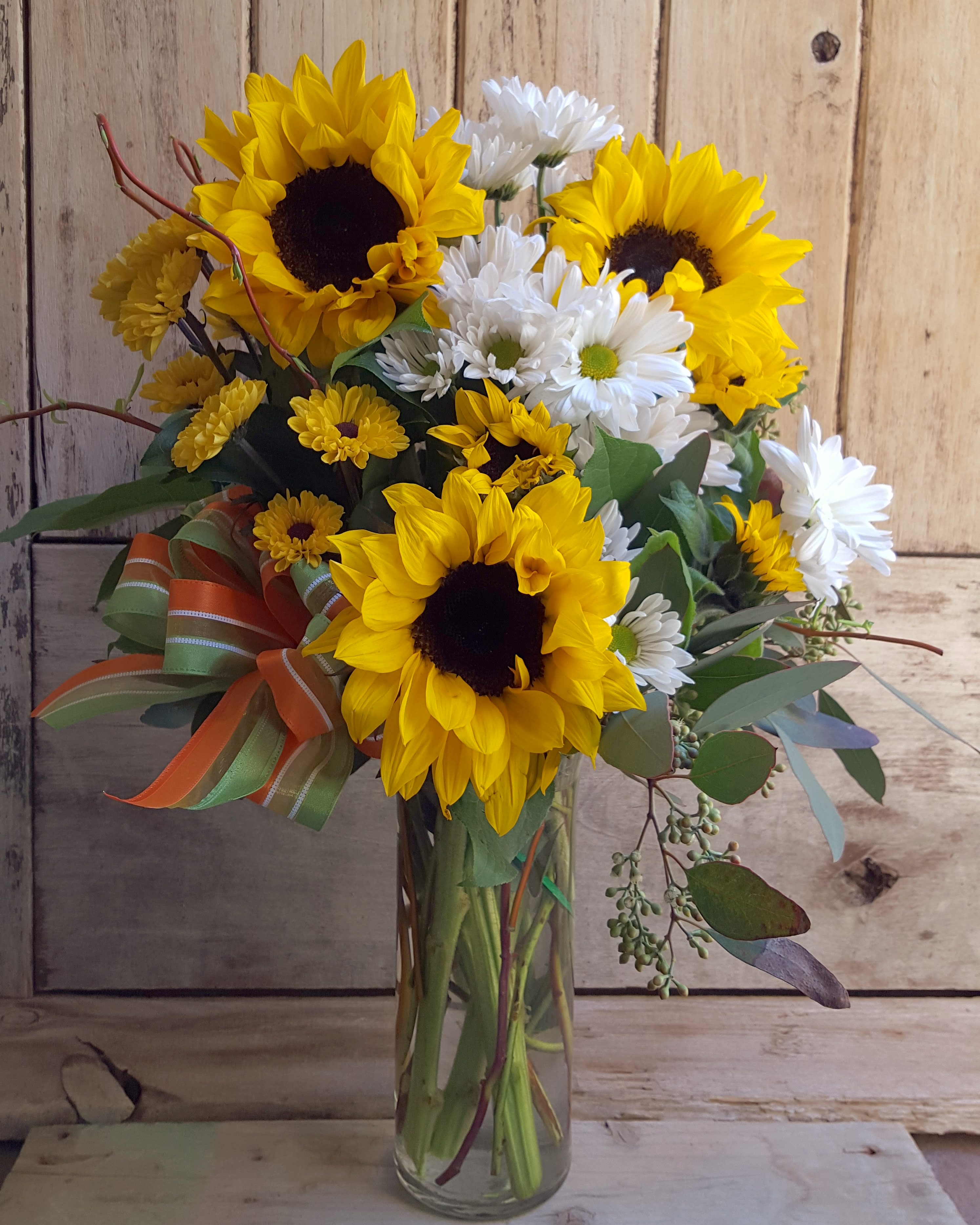 Sunny Daisy Vase - Because sunflowers beam happiness and always bring smiles. This beautiful arrangement is comprised of sunflowers and daisy's and measures approx 19" tall. 
