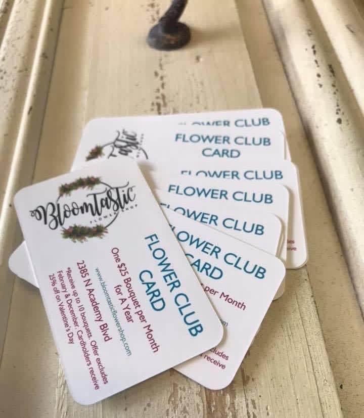 Stack of flower club cards on a wooden surface