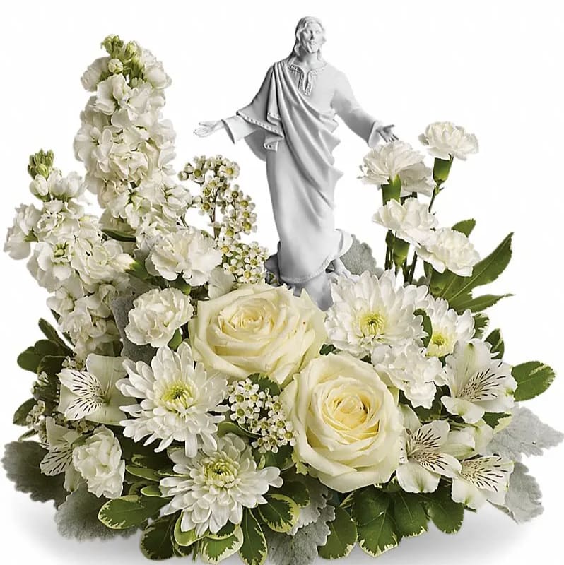 White floral arrangement with a statue of Jesus in the center