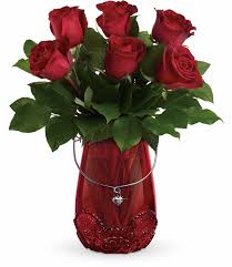 Bouquet of red roses in a red vase with a heart charm