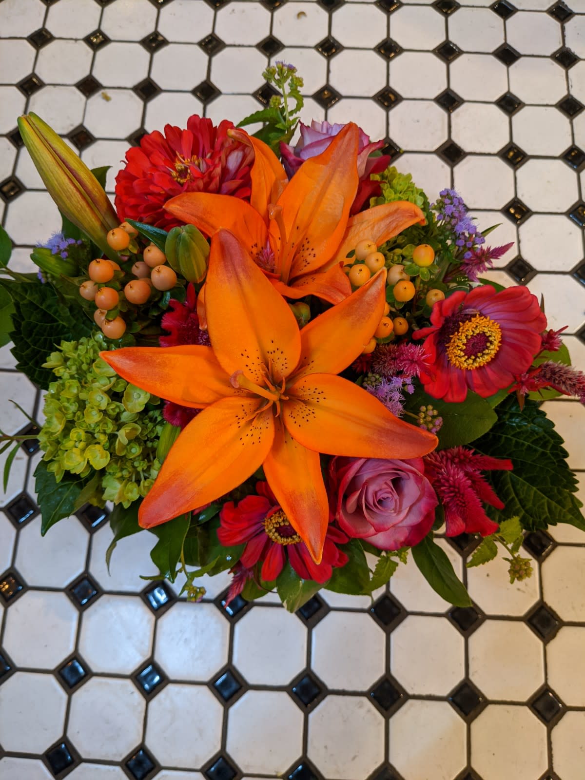 Bright mixed bouquet with orange lilies and red flowers