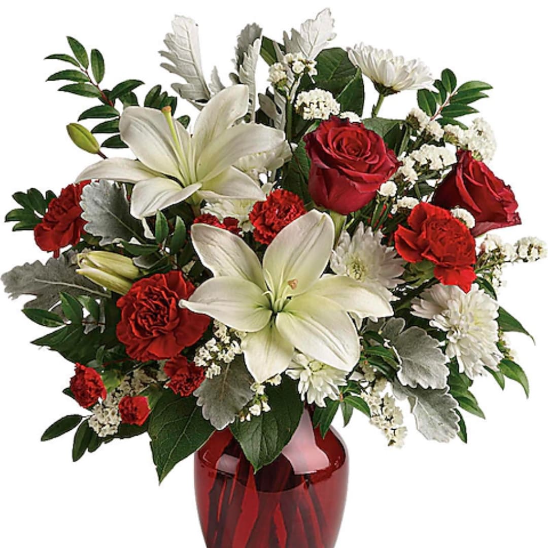 Red roses and white lilies in a red glass vase