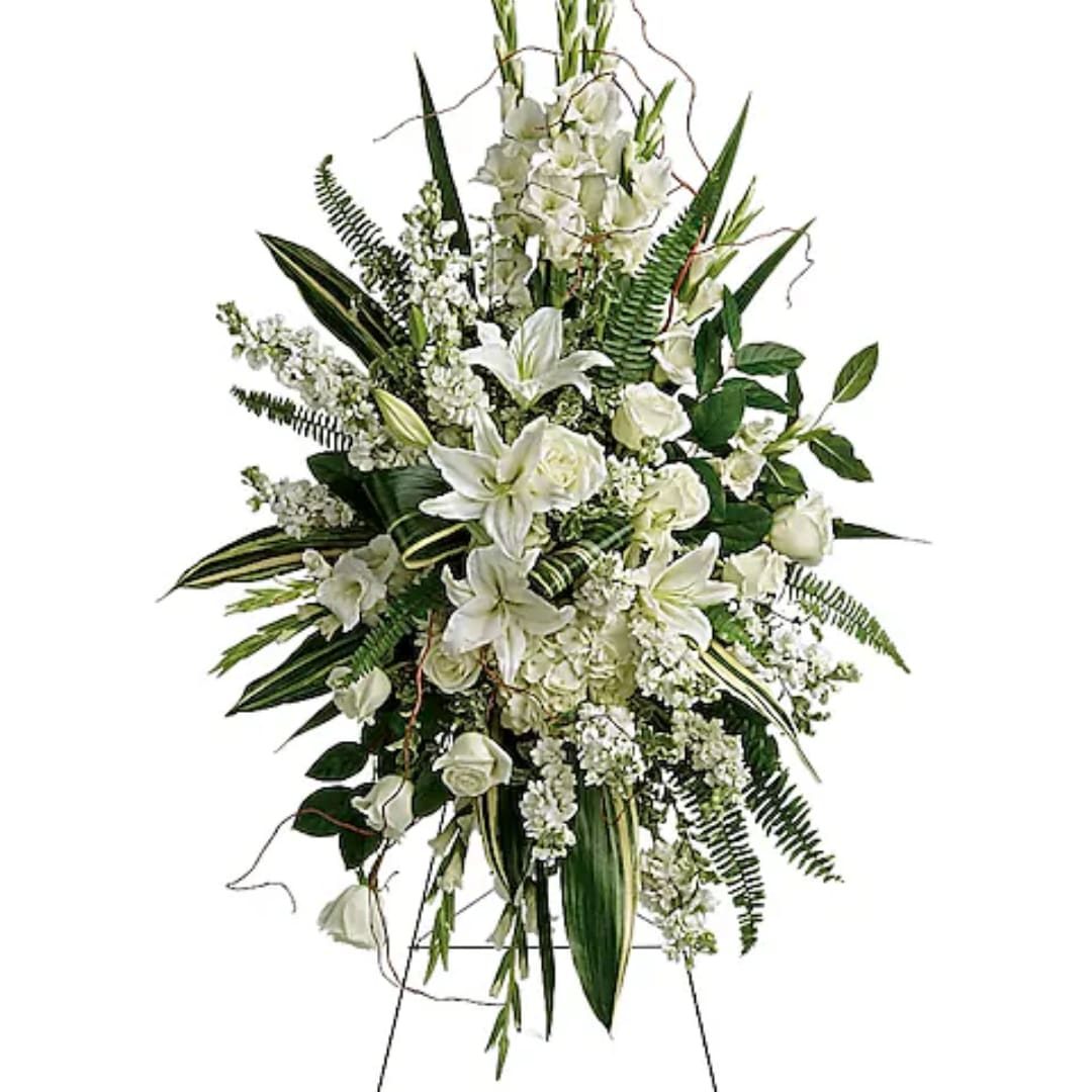 Tall white floral standing spray with lilies and roses on an easel