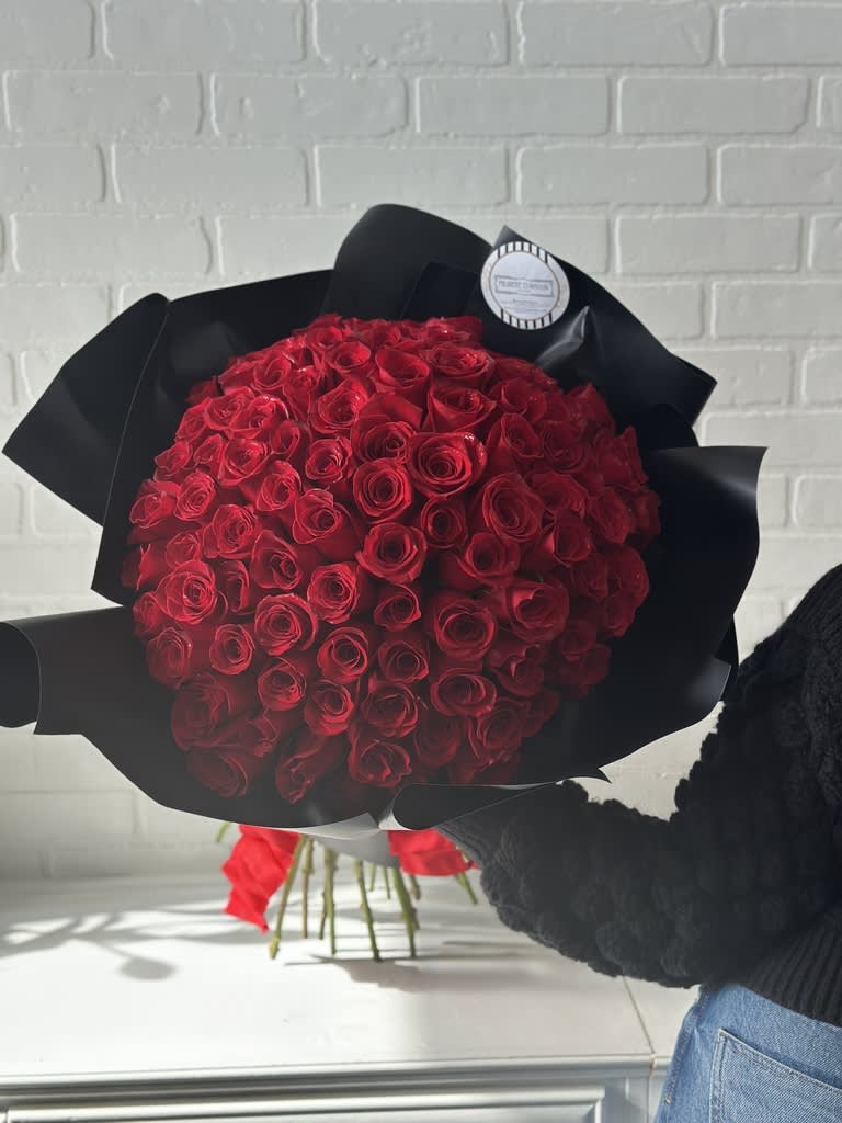 Large bouquet of red roses wrapped in black paper