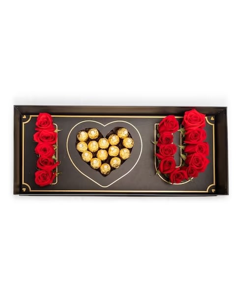 Heart-shaped chocolate box with red roses arranged around it