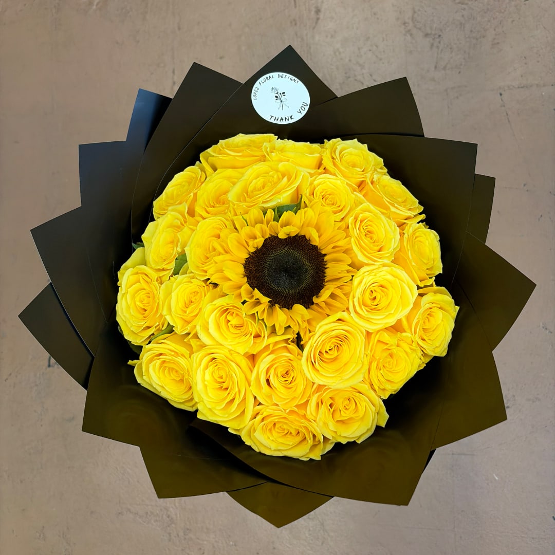 Yellow rose bouquet with a sunflower center wrapped in dark paper