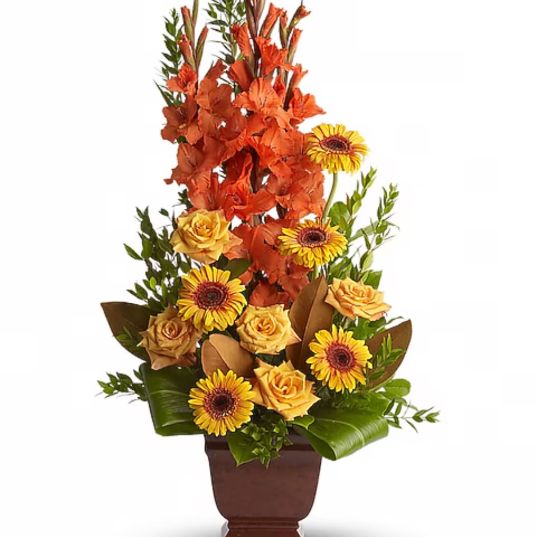 Tall orange and yellow floral arrangement in a brown vase
