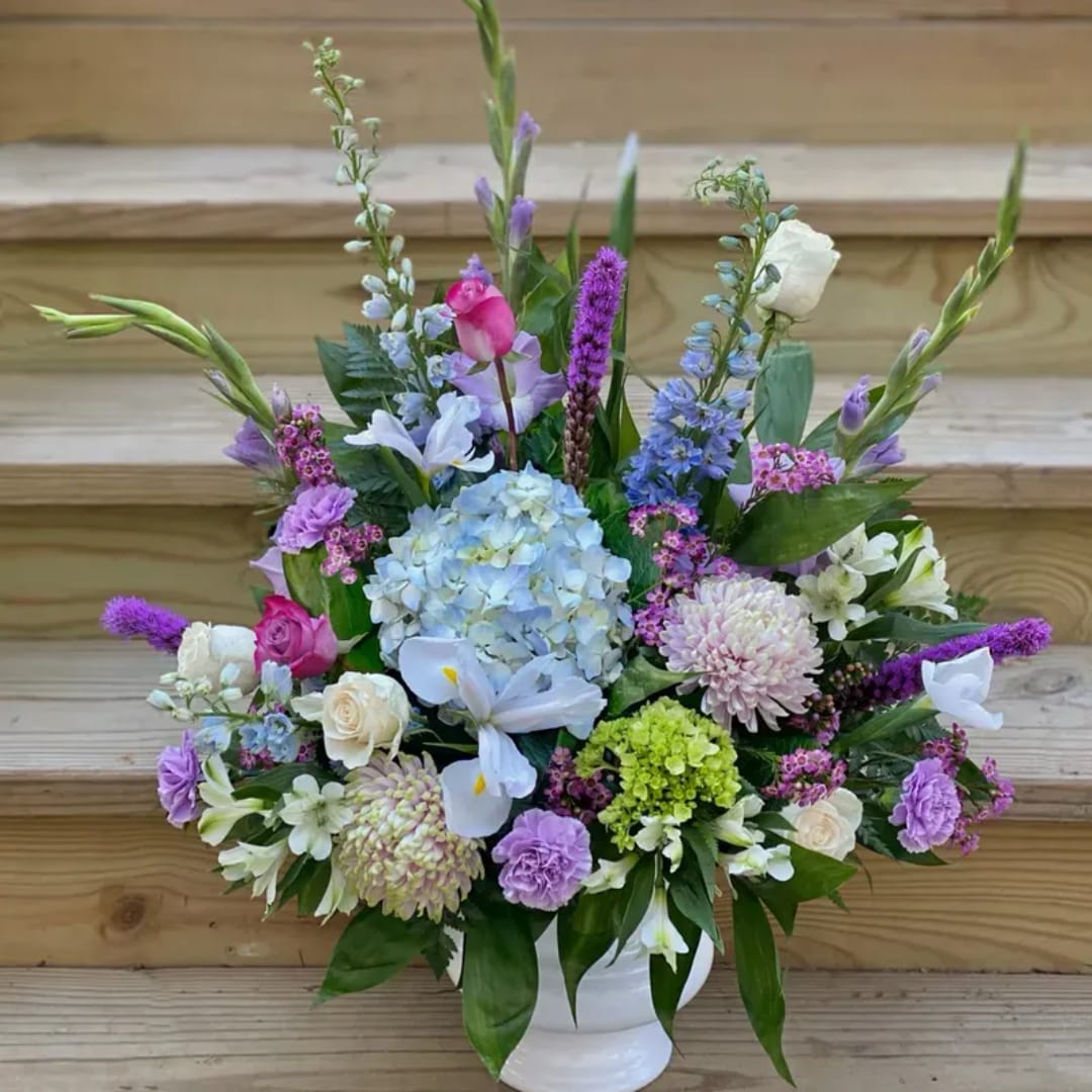 Mixed pastel flower arrangement in a white vase