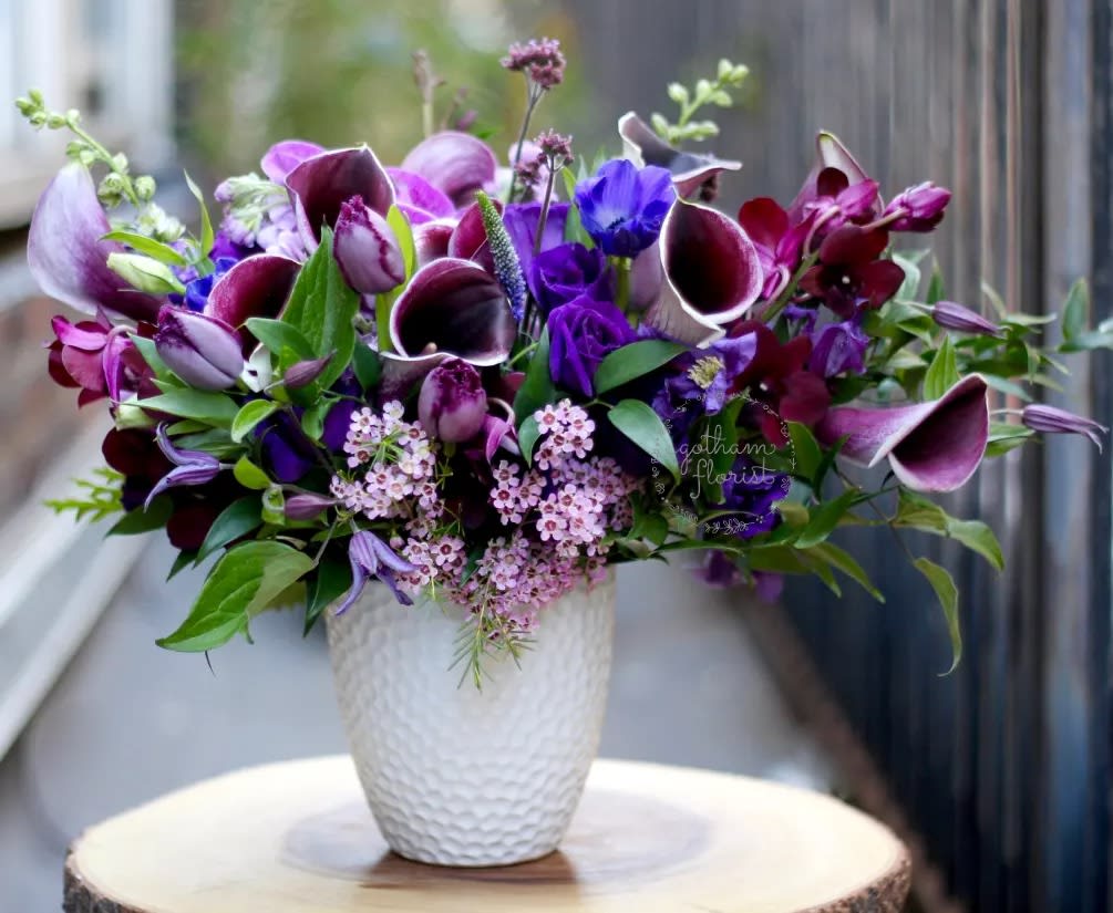 Purple and pink floral arrangement in a white textured vase