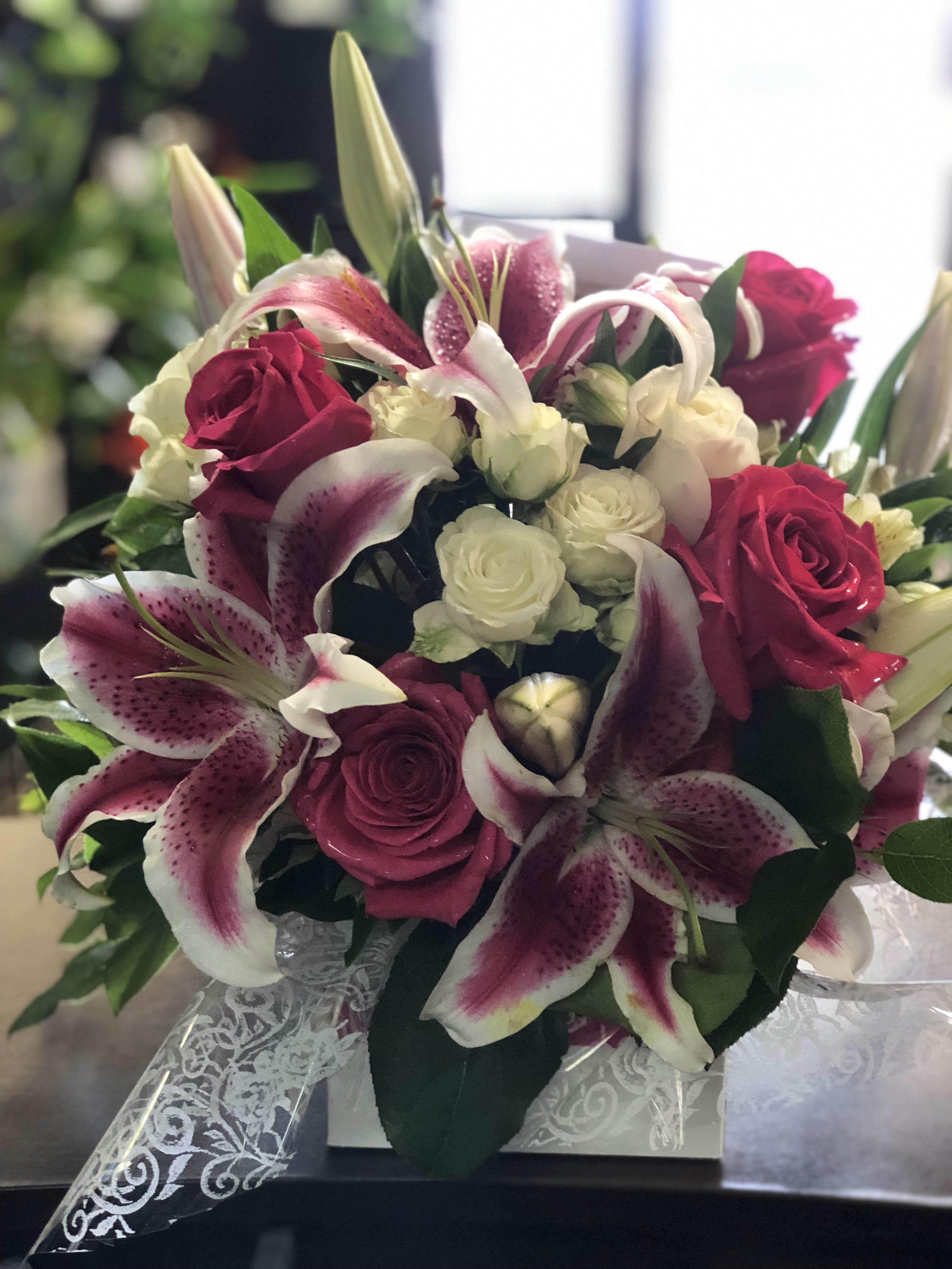 Bouquet of pink lilies and roses with white flowers