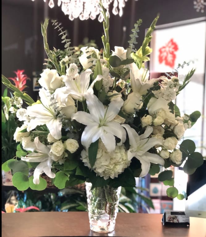 Sincerest Bouquet   - Express your sincere condolences with our elegant all-white arrangement of roses, lilies, stock, daisy poms and monte casino. A peaceful tribute that offers treasured memories of loved ones.  Abundant bouquet of the freshest white roses, lilies, stock, daisy poms and monte casino, accented with variegated pittosporum, salal and myrtle