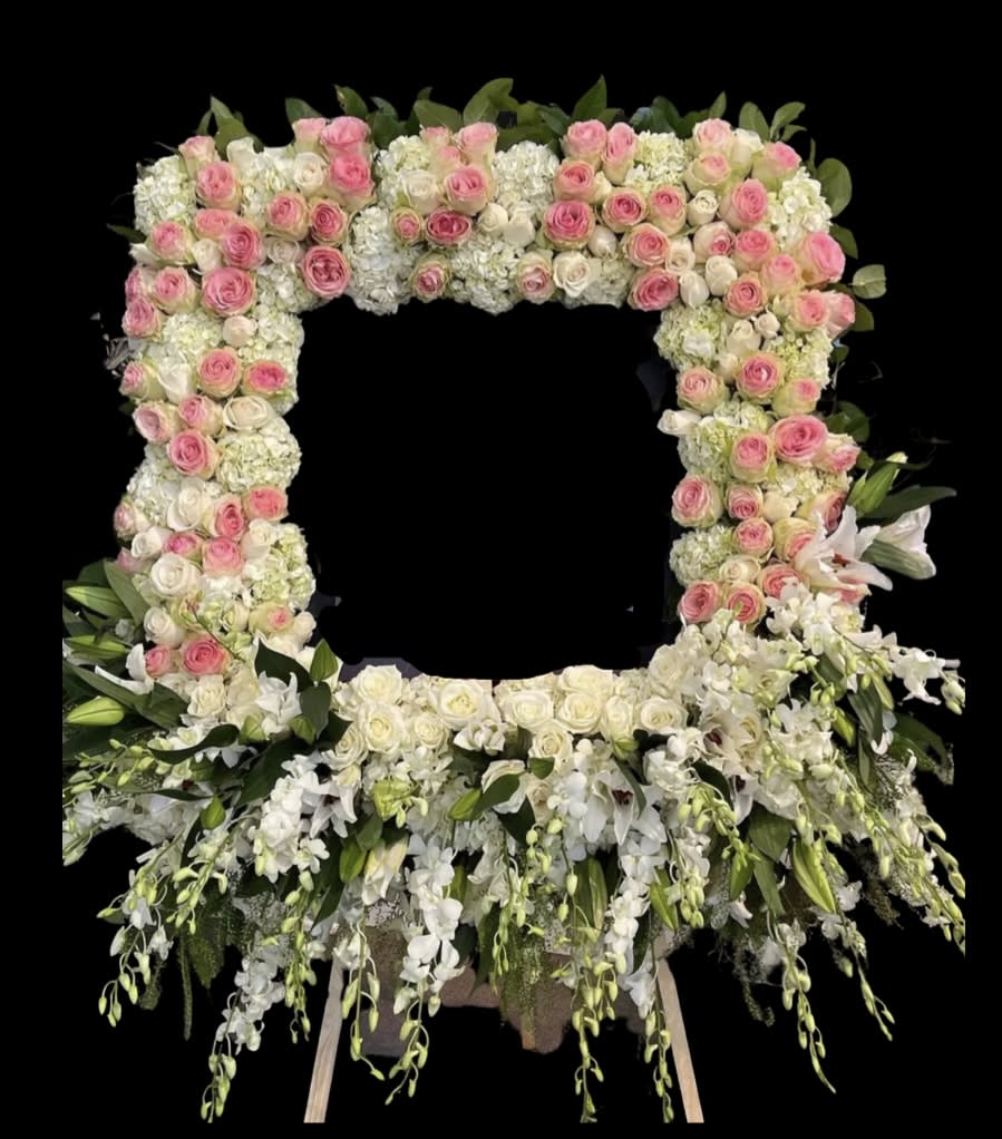 Large floral wreath of pink and white roses with cascading white flowers