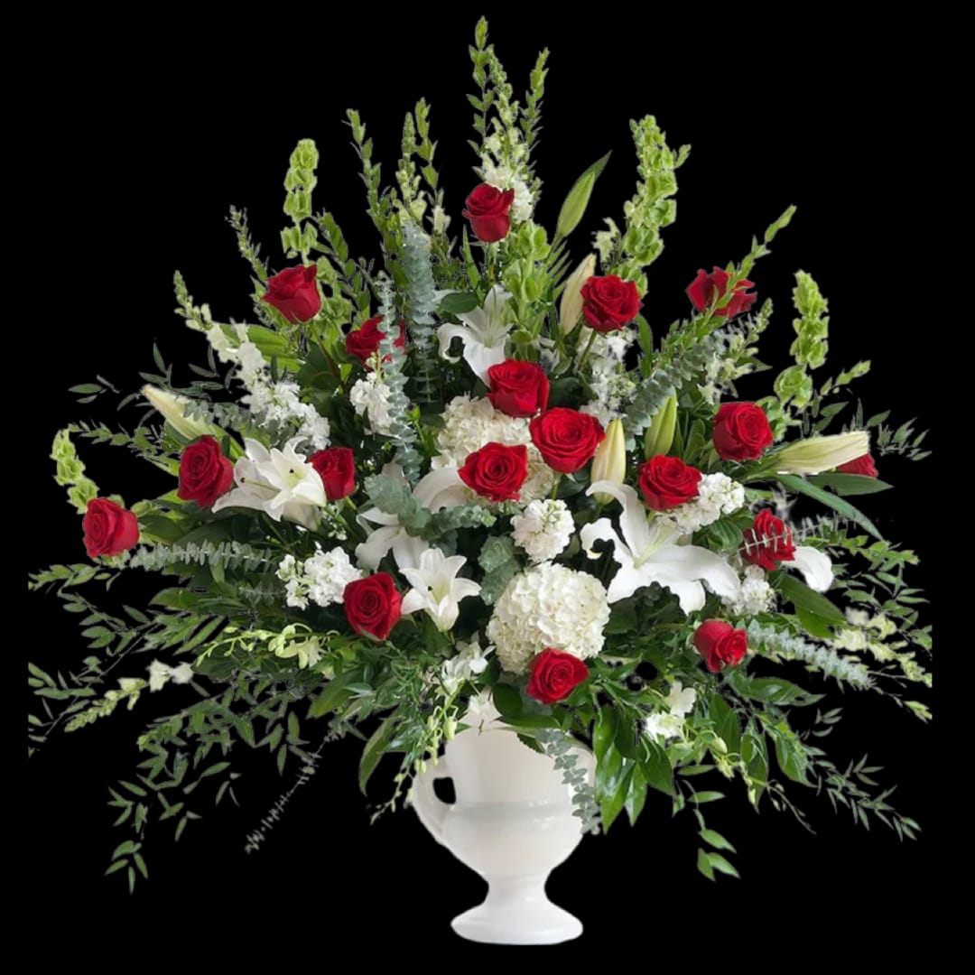 Large arrangement of red roses and white lilies in a white urn vase