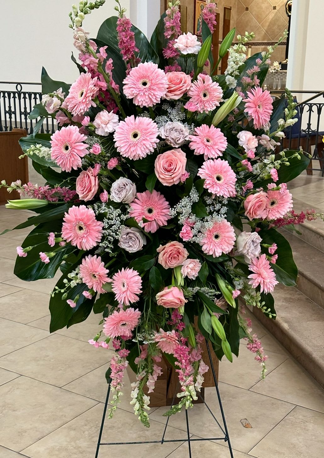 Large pink floral standing spray with gerbera daisies and roses