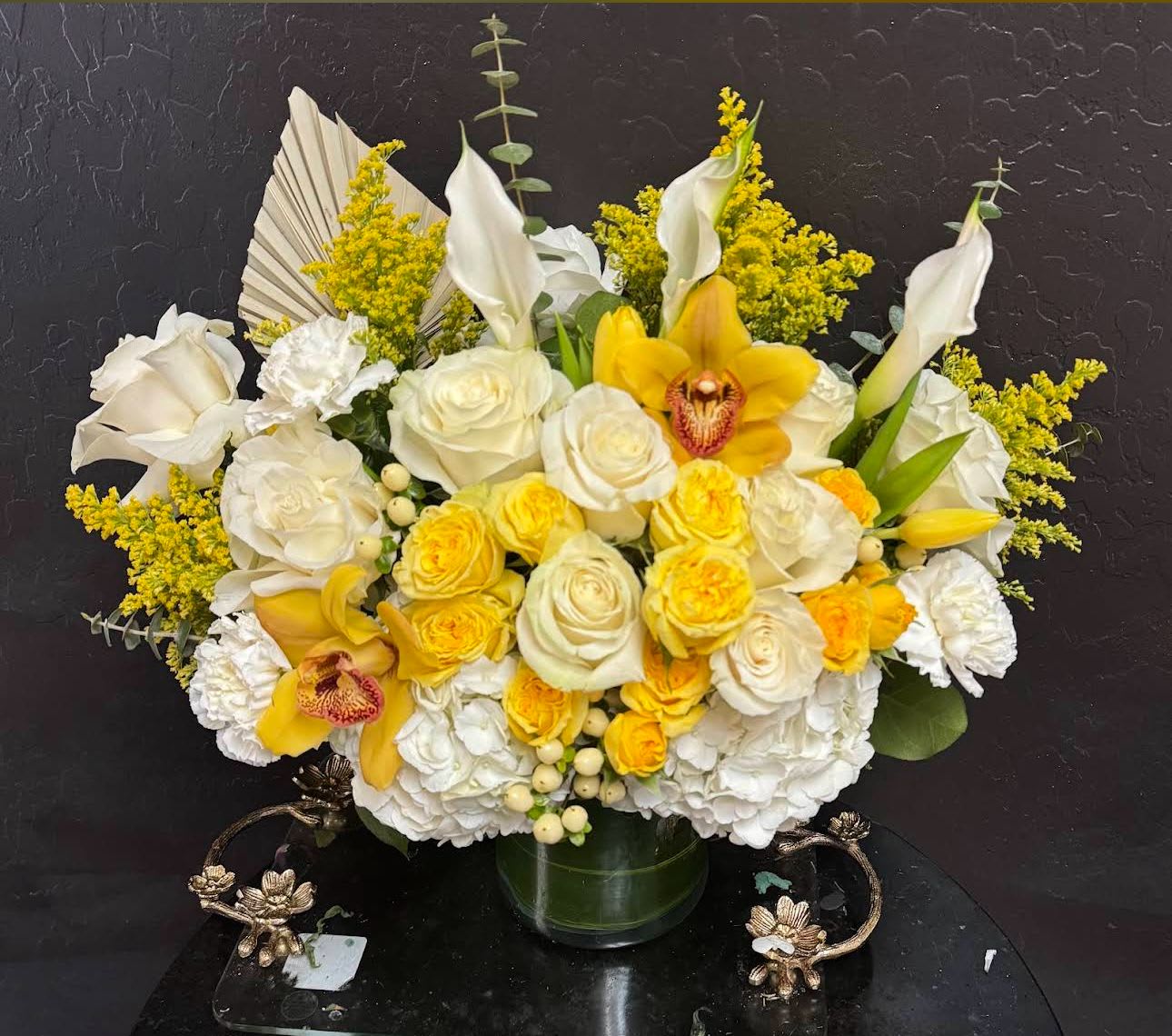 Yellow and white floral arrangement in a glass vase