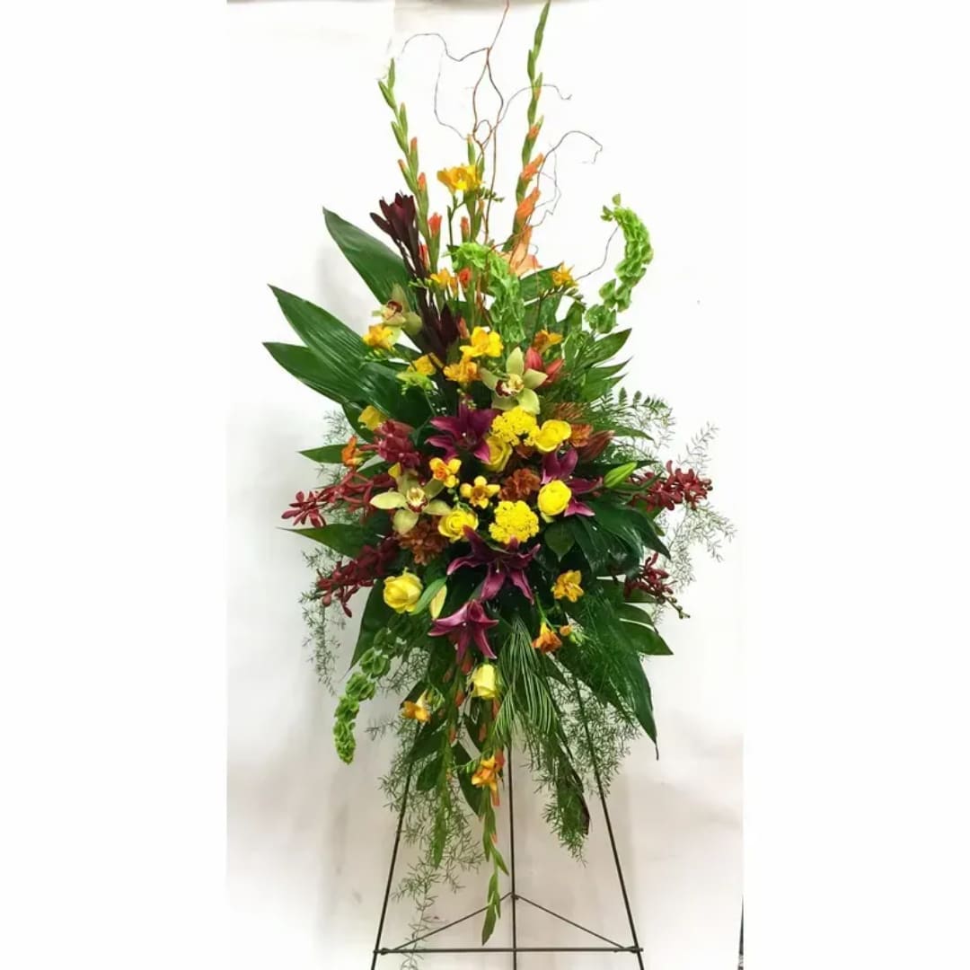 Tall standing floral spray with yellow, purple, and red blooms on a metal easel