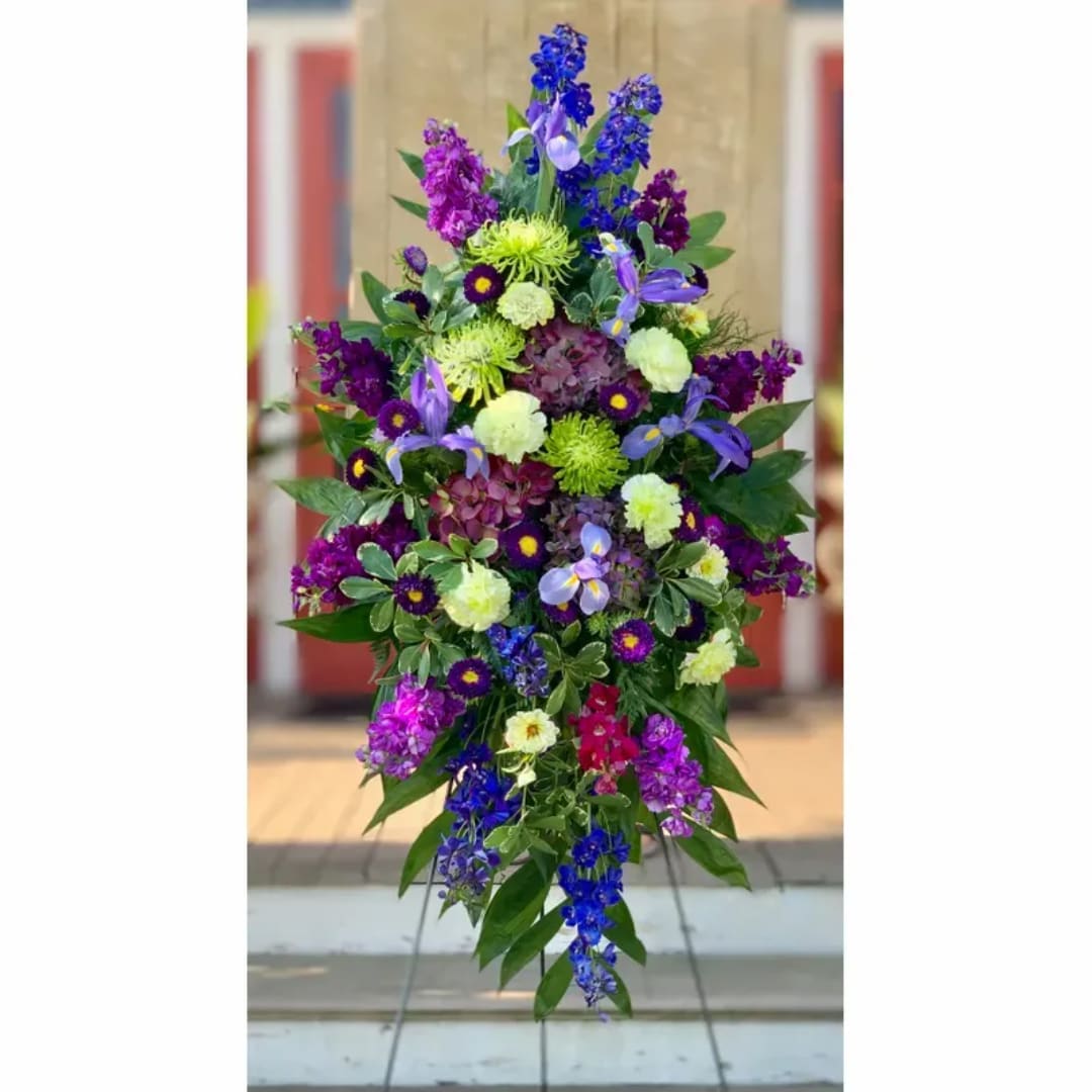 Tall standing floral spray with purple, blue, and lime blooms