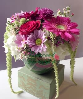 Pink and white mixed bouquet in a glass vase on a box