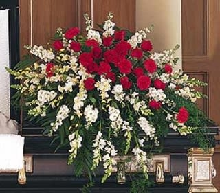 Large funeral spray of red and white flowers on a casket