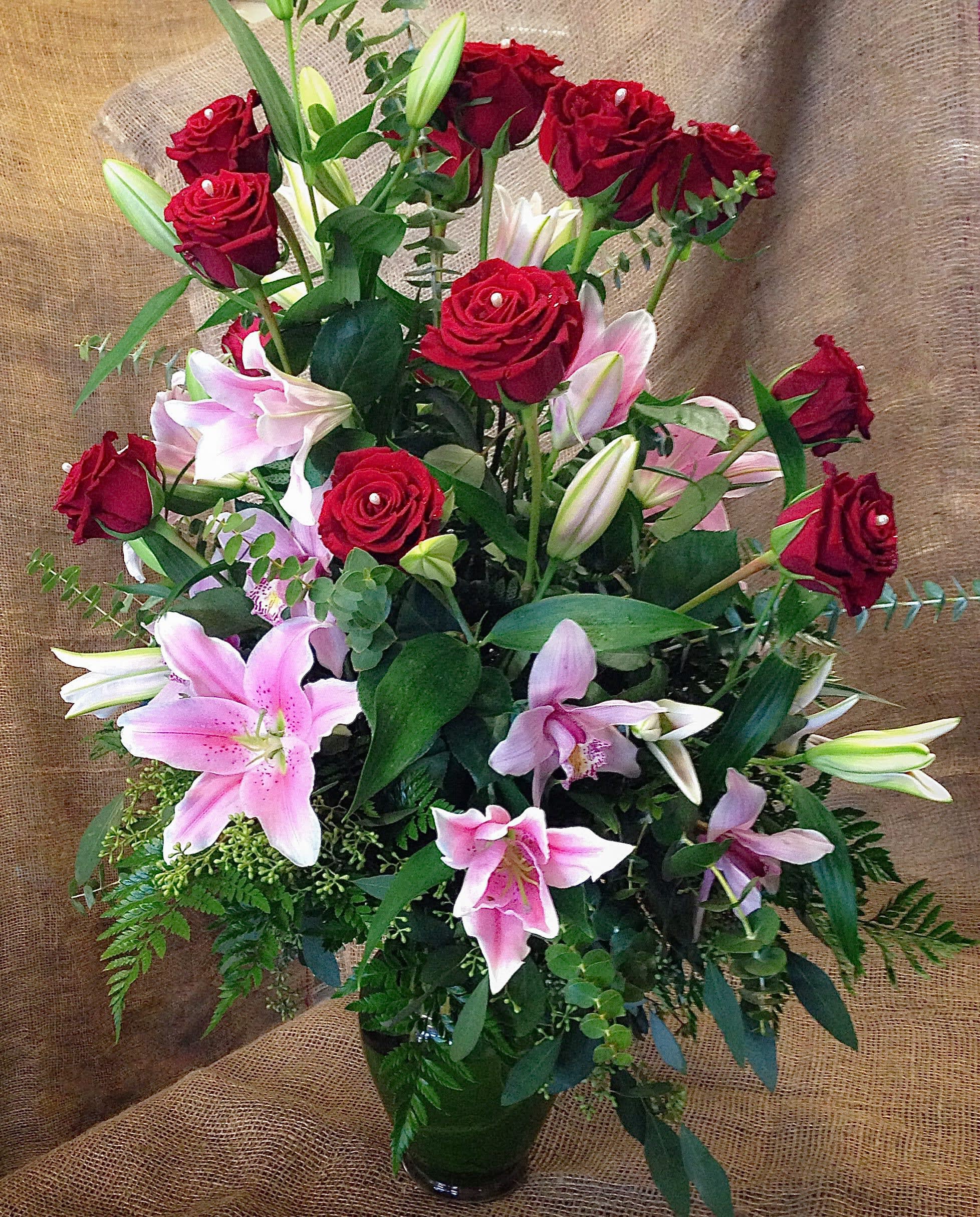 Red roses and pink lilies in a glass vase