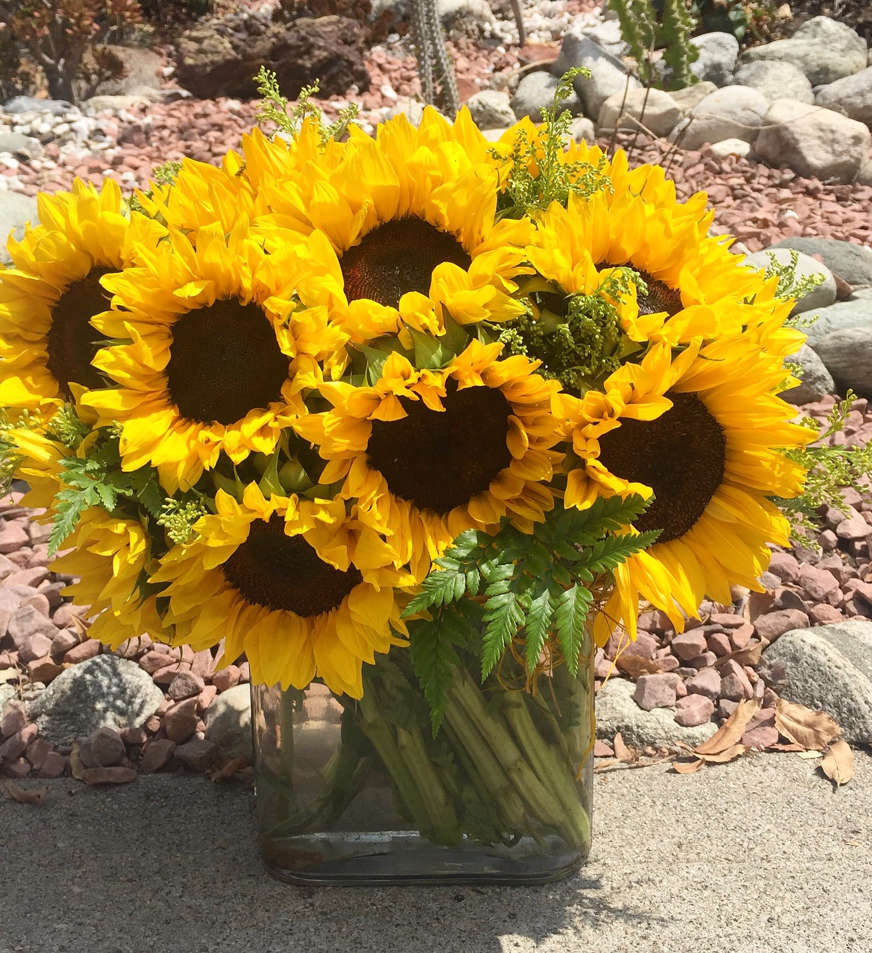 Bouquet of yellow sunflowers in a clear glass vase