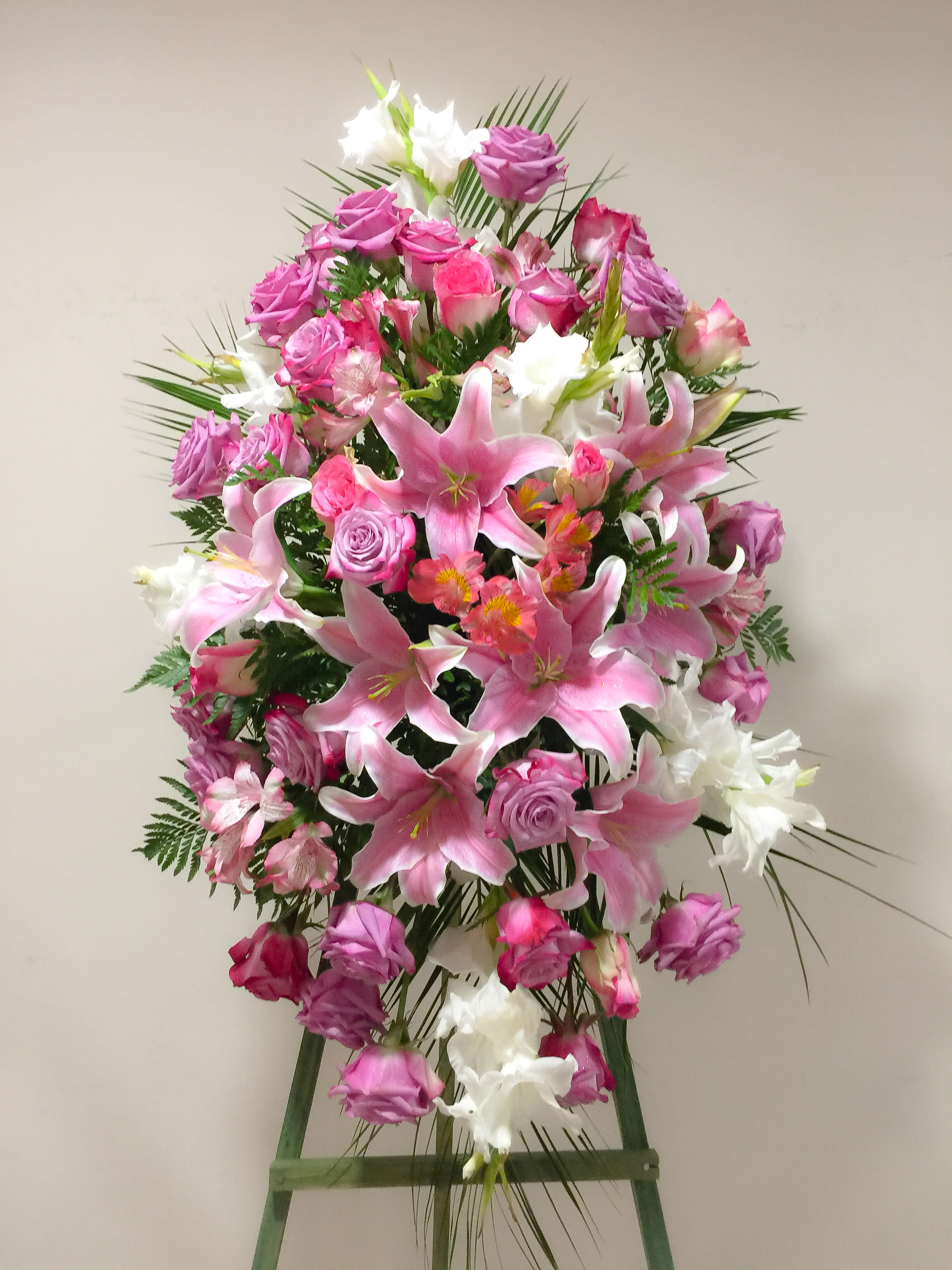 Tall standing floral spray with pink lilies, roses, and white blooms