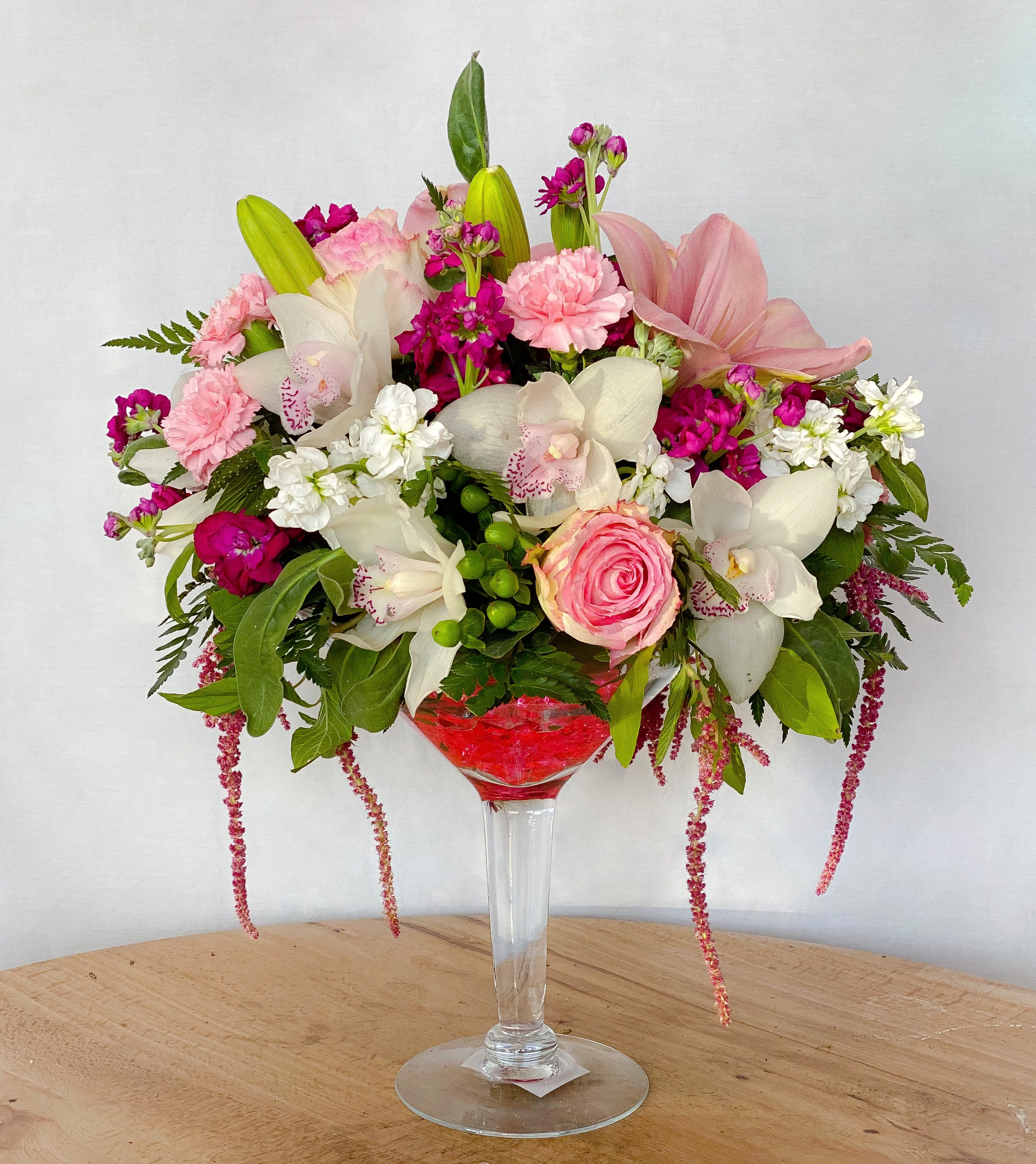 Pink and white floral arrangement in a tall glass vase