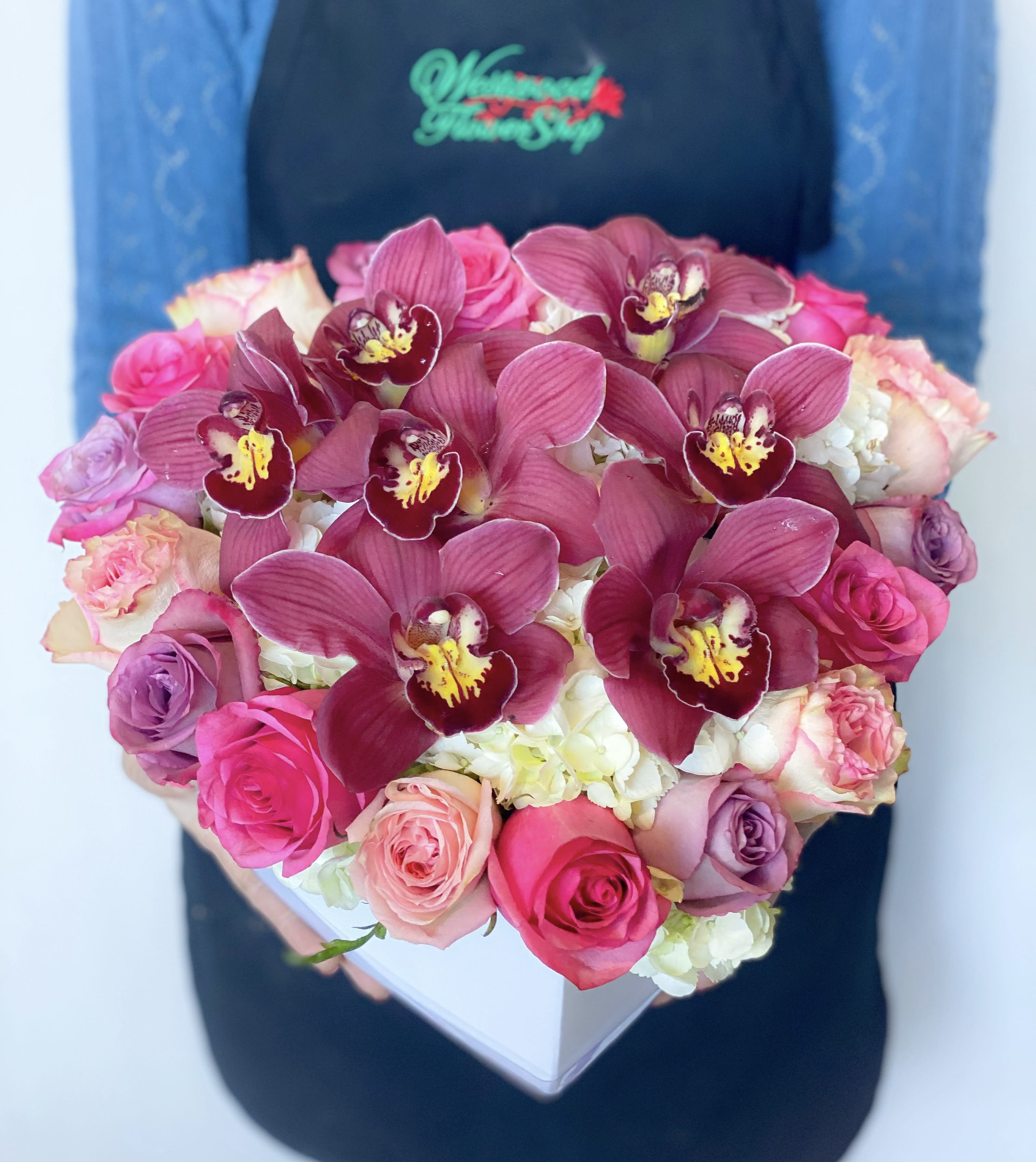 Heart-shaped box of pink roses and burgundy orchids