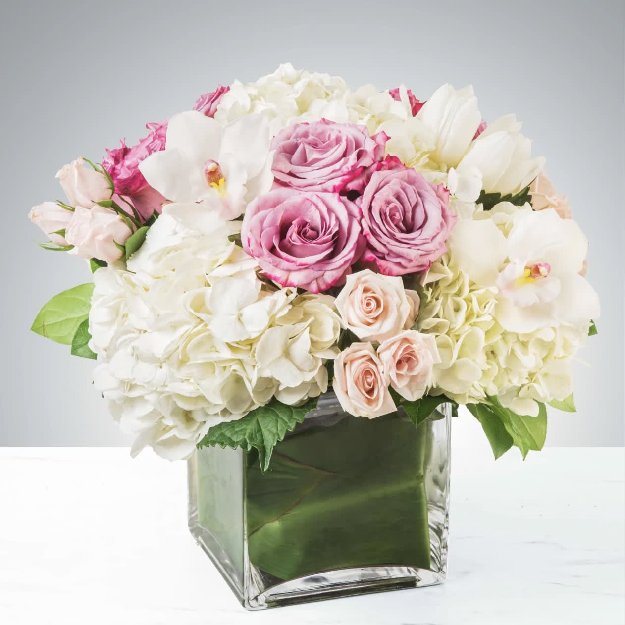 Carolina - Classic and Beautiful, this large arrangement whispers luxury. Soft pinks, whites and creams come together to create an appealingly feminine gift. Perfect for welcoming a new baby, wishing happy birthday or saying congratulations.   Approximately 9" D   