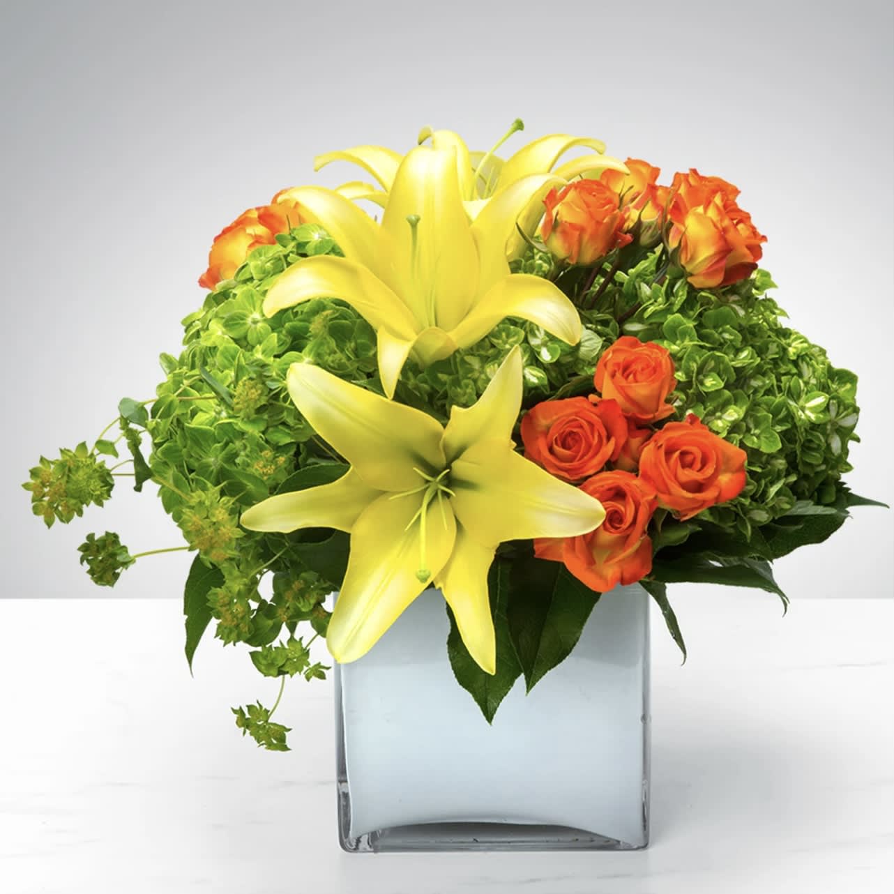 Cube of Wonder  - Do you find yourself wondering what’s in this Cube of Wonder? Wonder no longer, you’ve come to the right place. Featuring a vibrant array of lilies, spray roses, and hydrangea, this wonderful arrangement is the perfect gift to celebrate a birthday or new beginnings.  Approximately 9" D