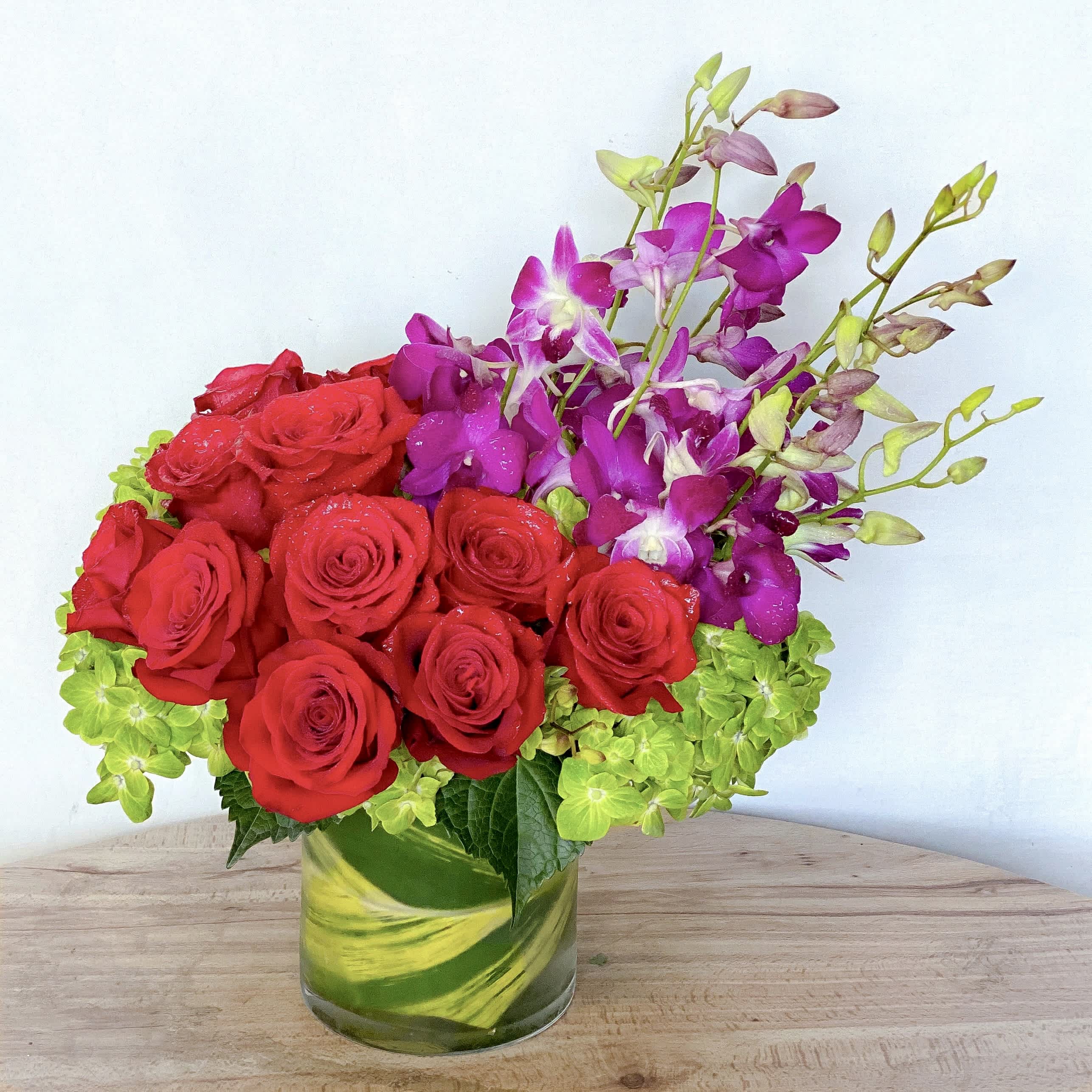 Bejeweled Nights - A celebration of luxury and life, this large and jewel toned arrangement is enough to stop anybody in their tracks. Roses, orchids and hydrangeas come together in this purely floral masterpiece.    Approximately  14” D