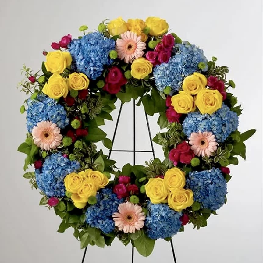 Vivid Spring Round Wreath - This colorful and bright wreath spray is representative of a life lived to its fullest. Colors and Flowers may change based off of season and availability.   Approximately 22" D