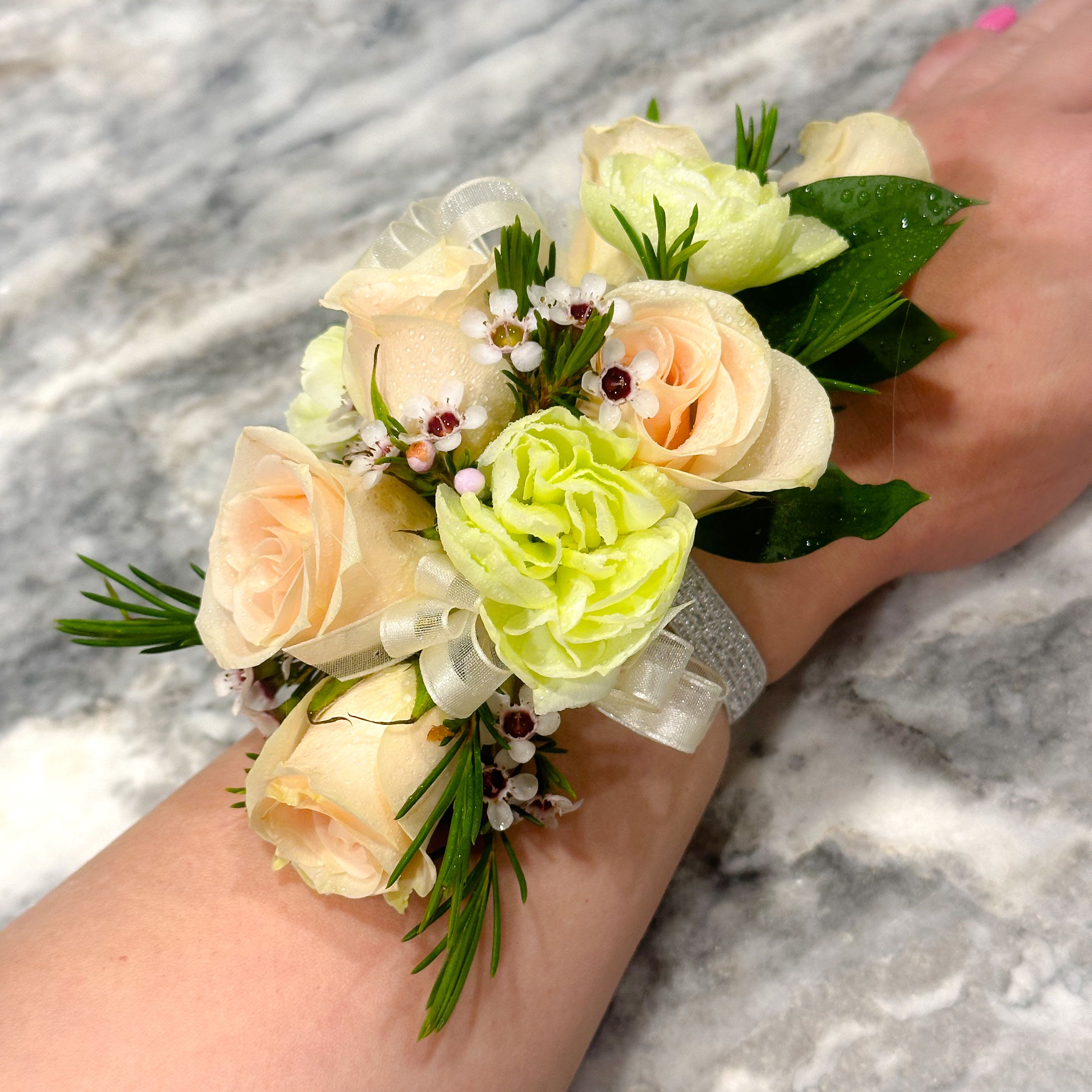 Wrist corsage with pale peach roses and light green blooms