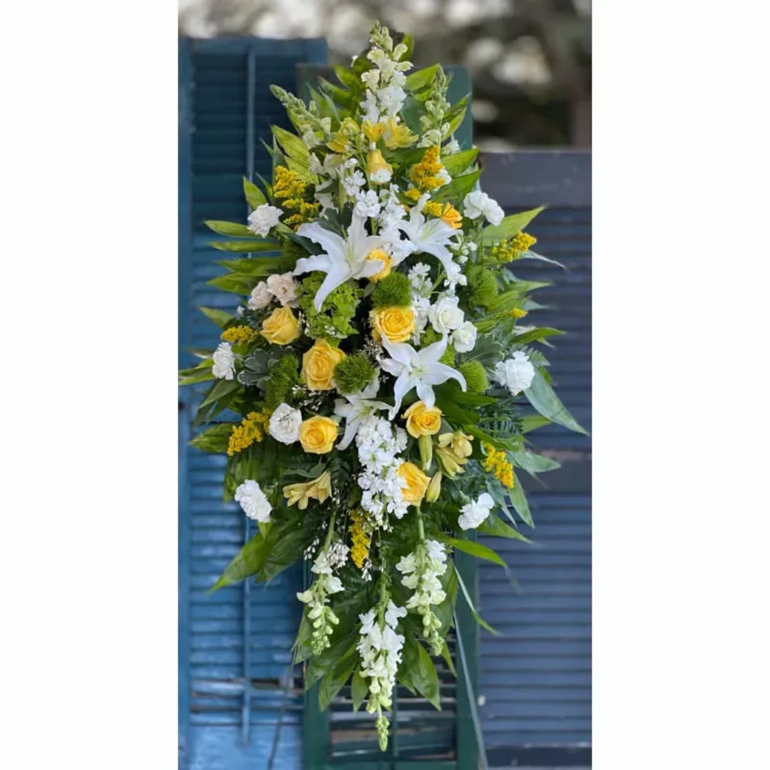 Tall floral spray with white lilies, yellow roses, and green accents