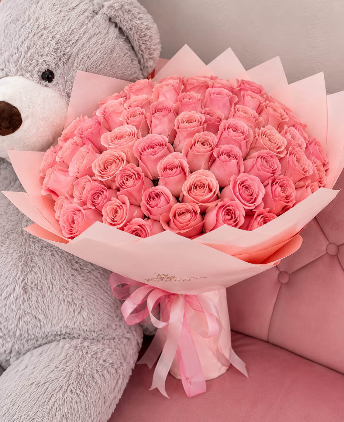 100 light pink Roses  - A cloud of one hundred light pink roses forms an unforgettable anniversary or birthday bouquet that reads as pure romance and gentle appreciation - perfect for Mother's Day, Valentine's Day, or any "just because" moment when you want her to feel truly cherished. The tightly packed dome of pale pink blooms creates a soft, feminine silhouette that says thoughtful admiration, making it equally fitting for graduations, weddings, new baby celebrations, or to comfort someone during a get-well or sympathy moment.  Every rose is arranged into a full, rounded bouquet and wrapped in soft pink paper that reinforces the monochromatic palette; a few translucent butterfly picks add a whimsical, delicate accent. This gift-ready presentation arrives smelling softly of fresh roses and makes a grand statement for housewarmings, retirements, Mother's Day, or to say "I'm sorry" or "thank you." Choose this arrangement to make the recipient feel genuinely seen - it's designed to arrive ready to display and enjoy, with care best kept in fresh water and out of direct heat to extend vase life.