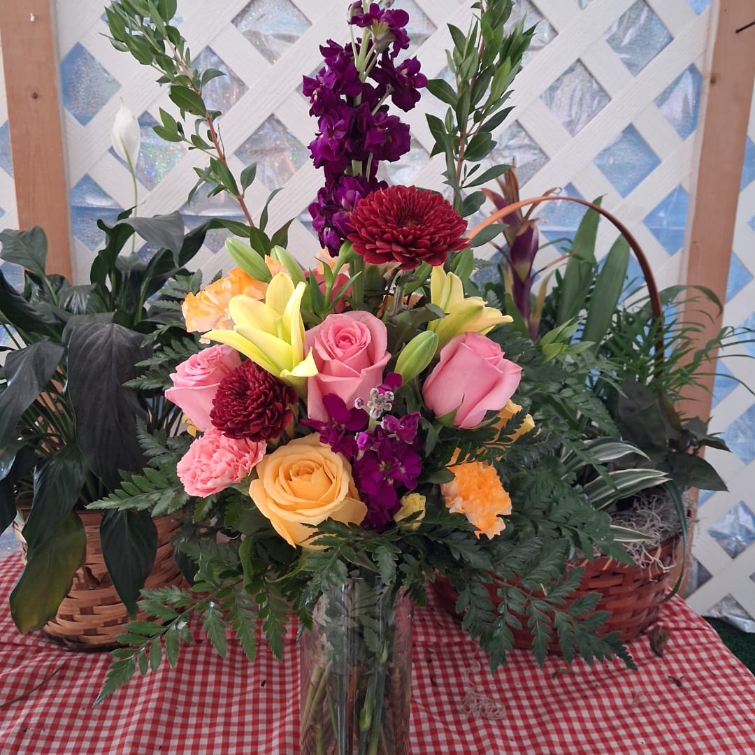 Mixed bouquet in a clear glass vase with pink, yellow, and purple flowers