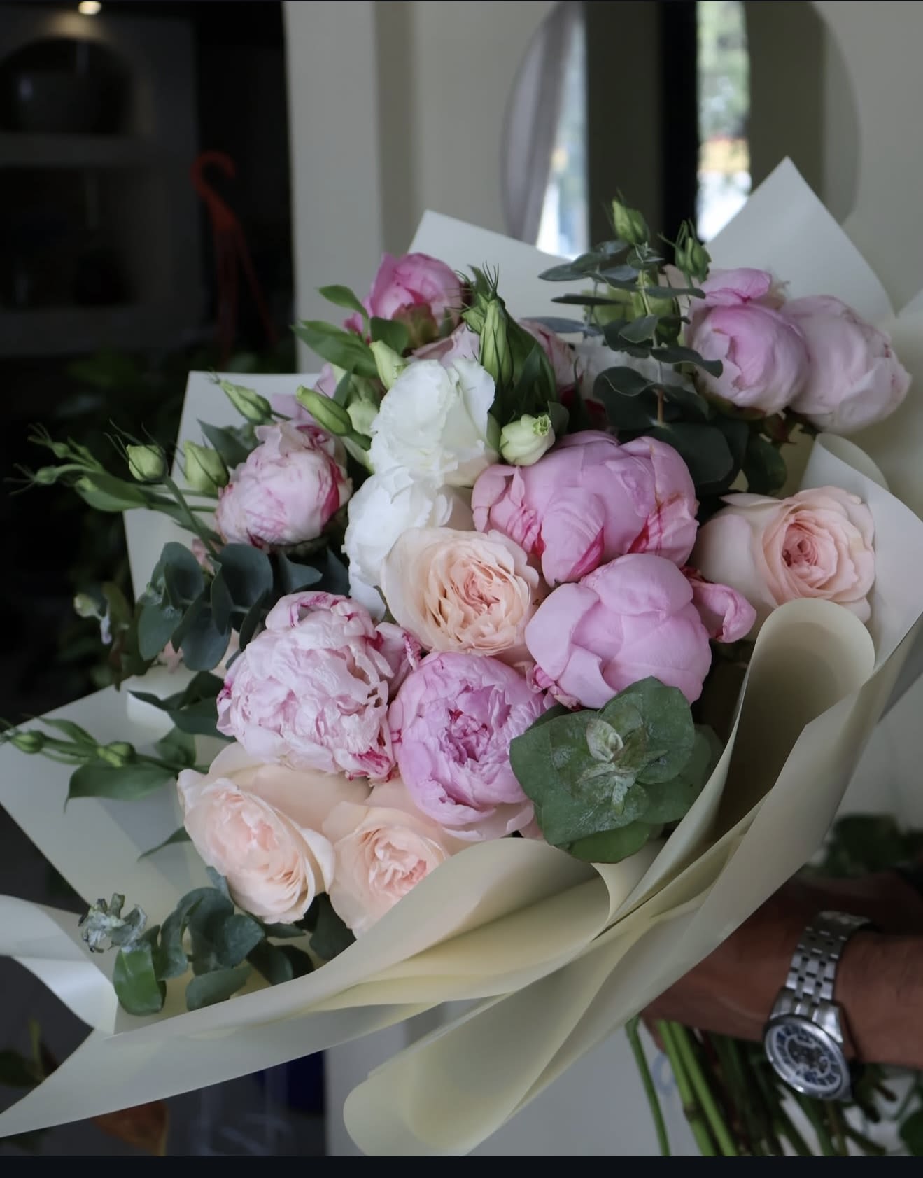 Bouquet of pink and white peonies with eucalyptus in cream wrap