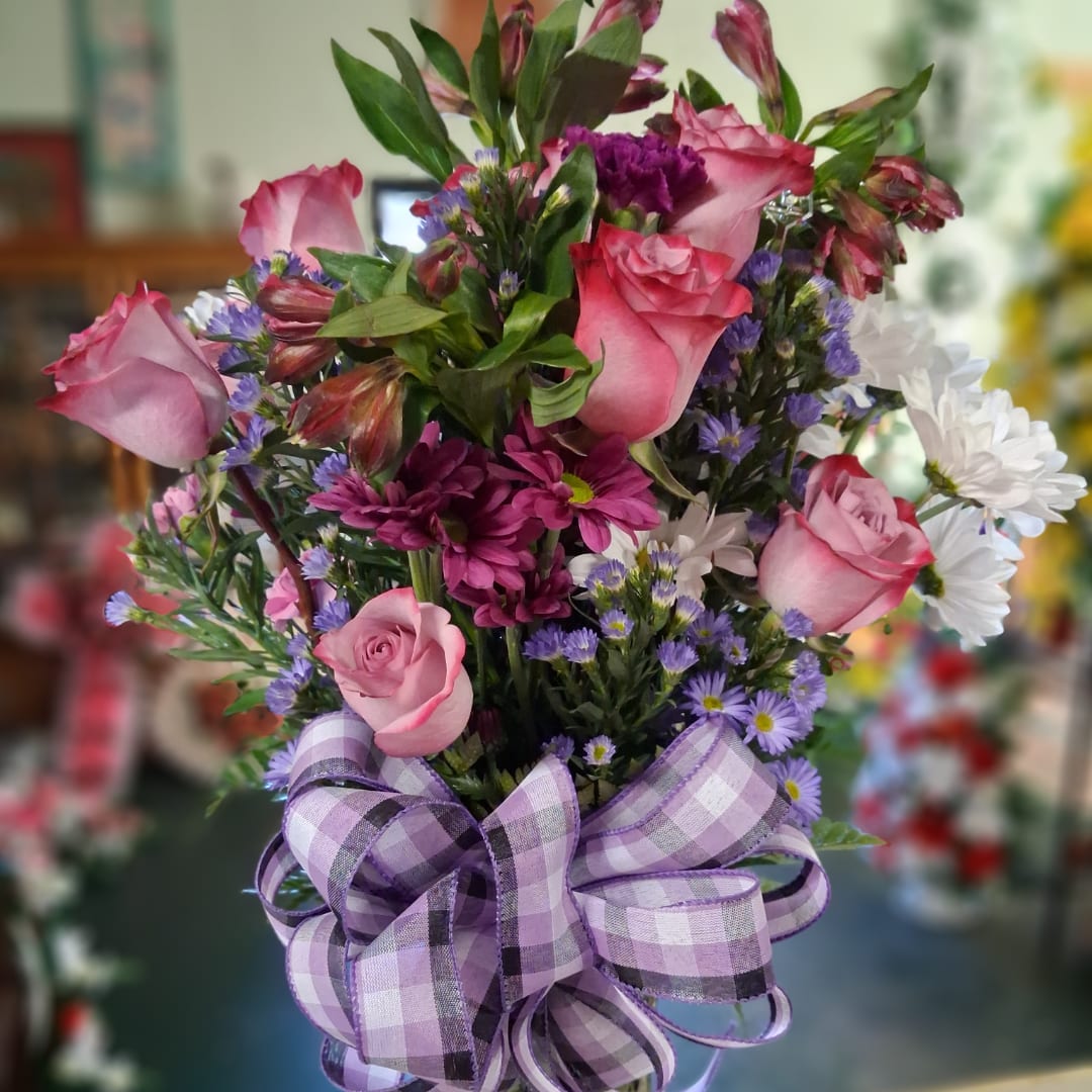 Bouquet of pink roses, purple daisies, and white daisies with a purple plaid bow