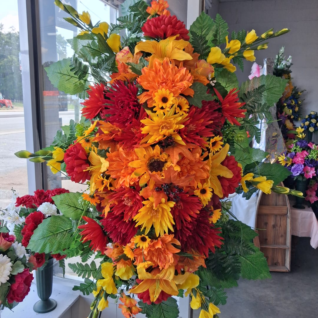 Large arrangement of red, orange, and yellow flowers with greenery