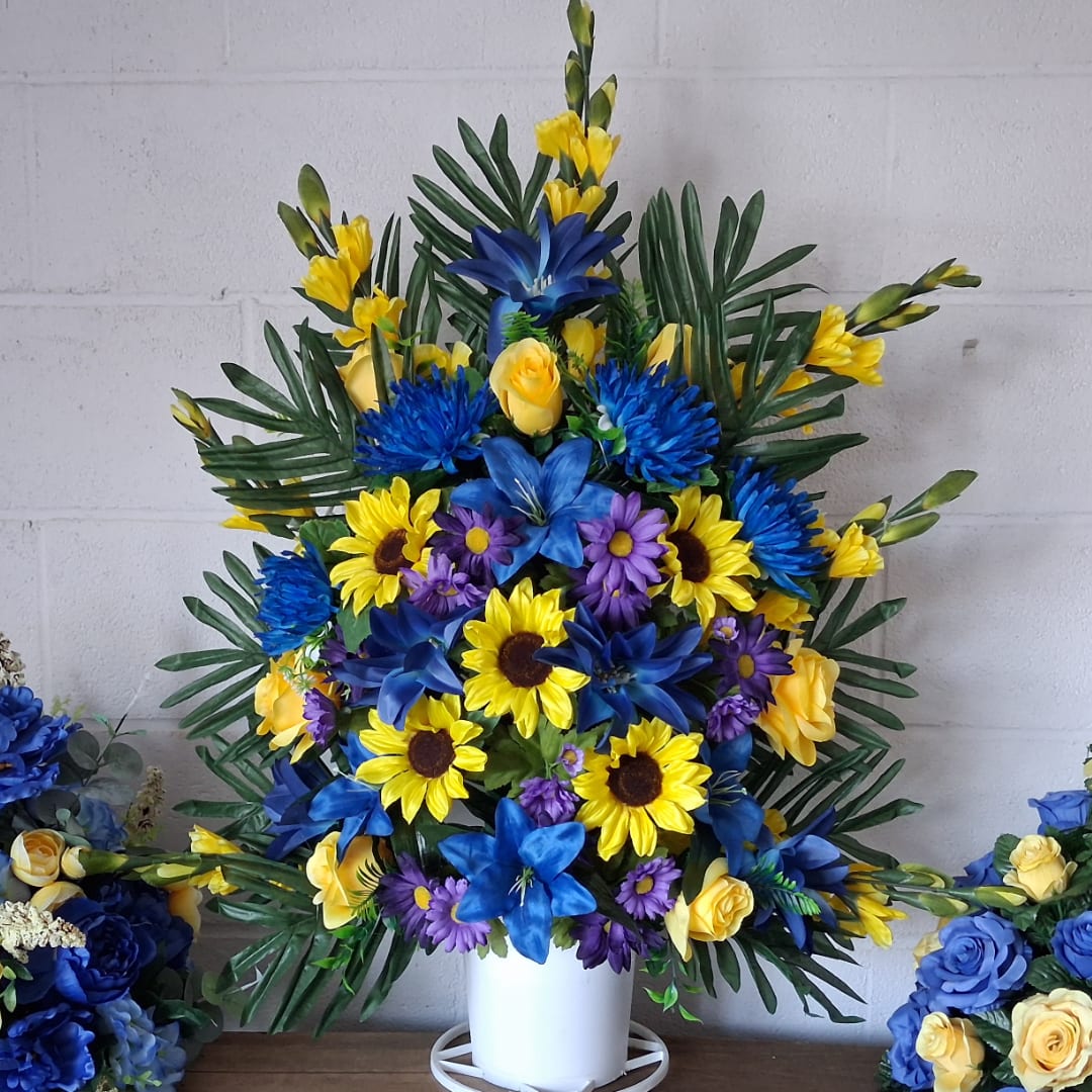 Blue, yellow, and purple floral arrangement in a white vase