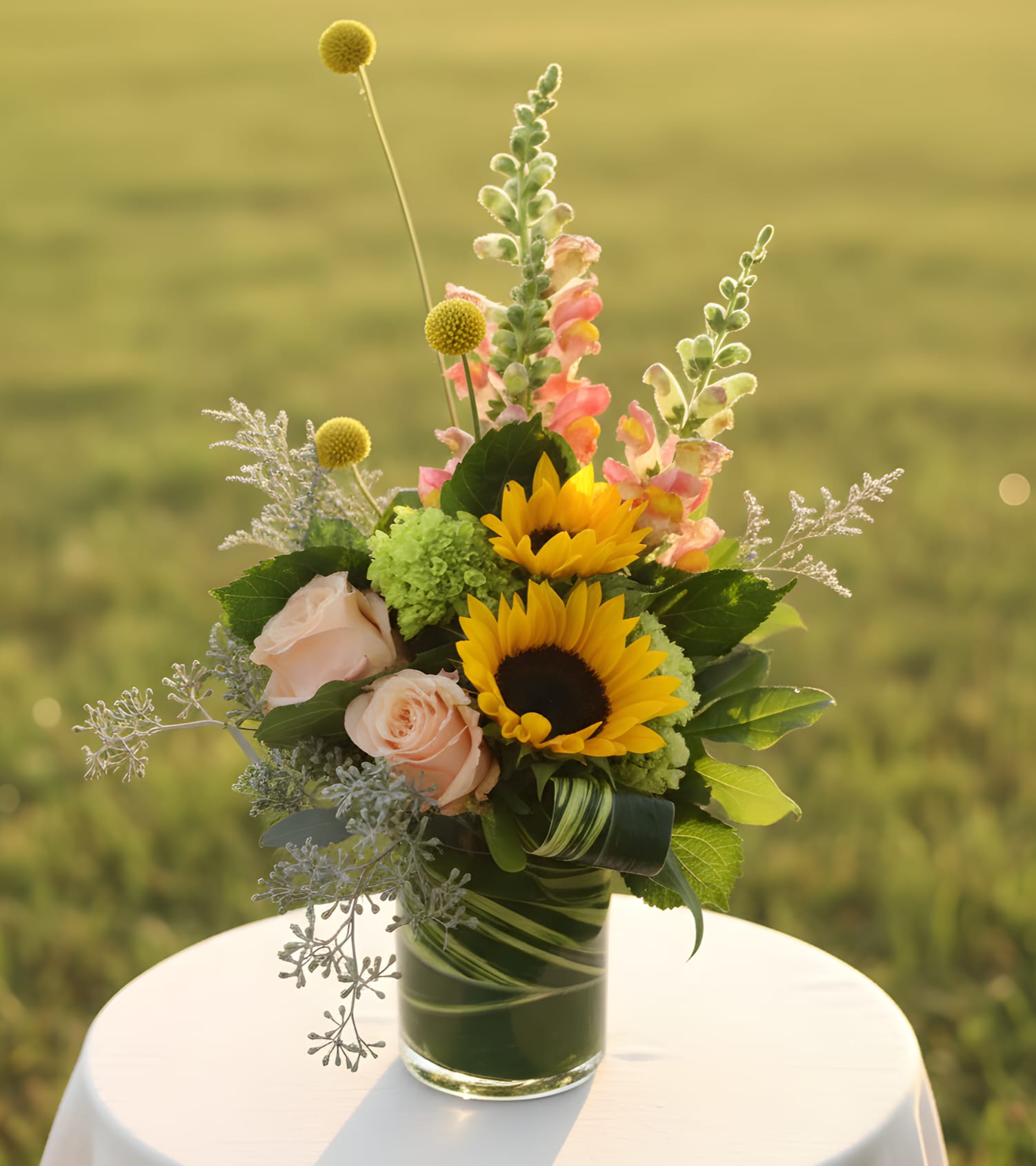 Sunflowers and pale pink roses in a glass vase