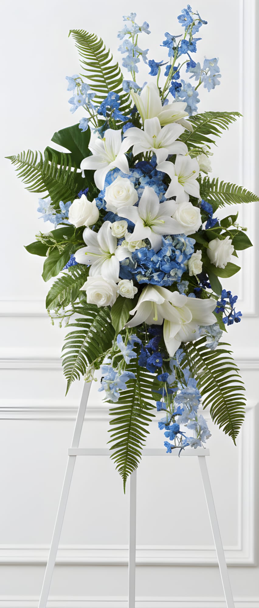Tall blue and white floral standing spray on an easel