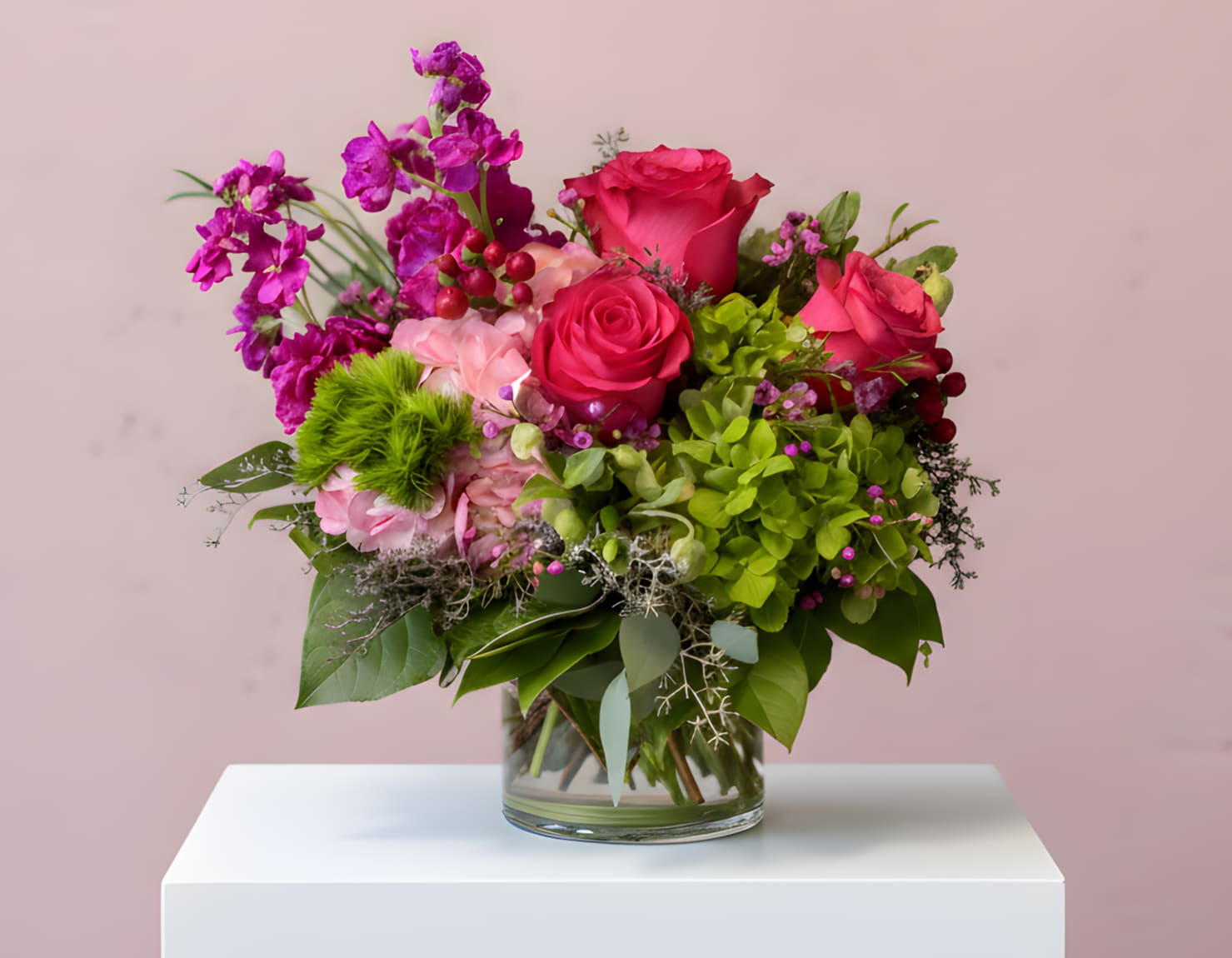 Bouquet of pink roses and purple orchids in a glass vase